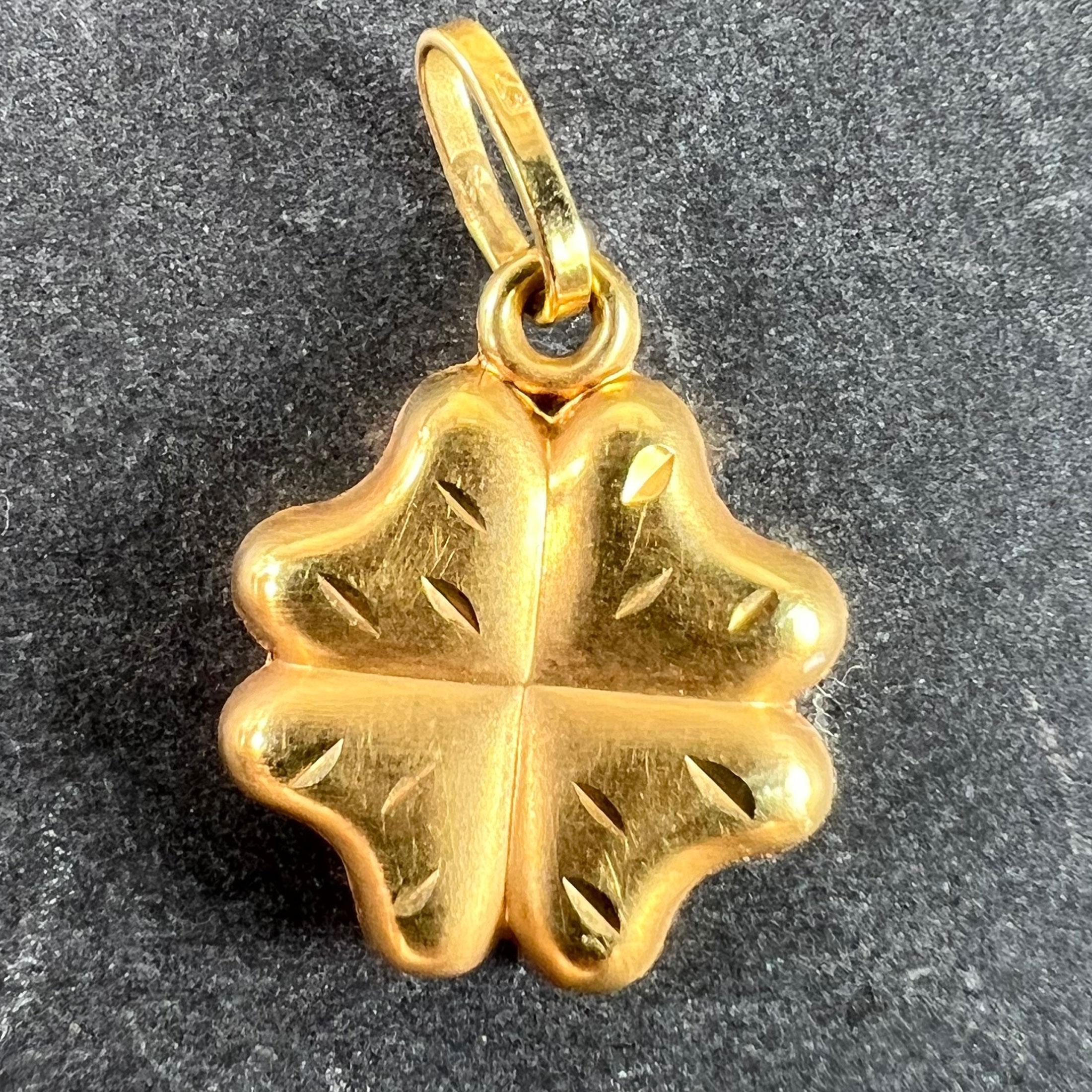 Ciondolo charme vintage in oro giallo 18 carati (18K) raffigurante un trifoglio gonfio o un quadrifoglio con foglie incise. Il timbro 750 sull'anello di sospensione indica che si tratta di oro a 18 carati.

Dimensioni: 1,4 x 1,1 x 0,3 cm (escluso