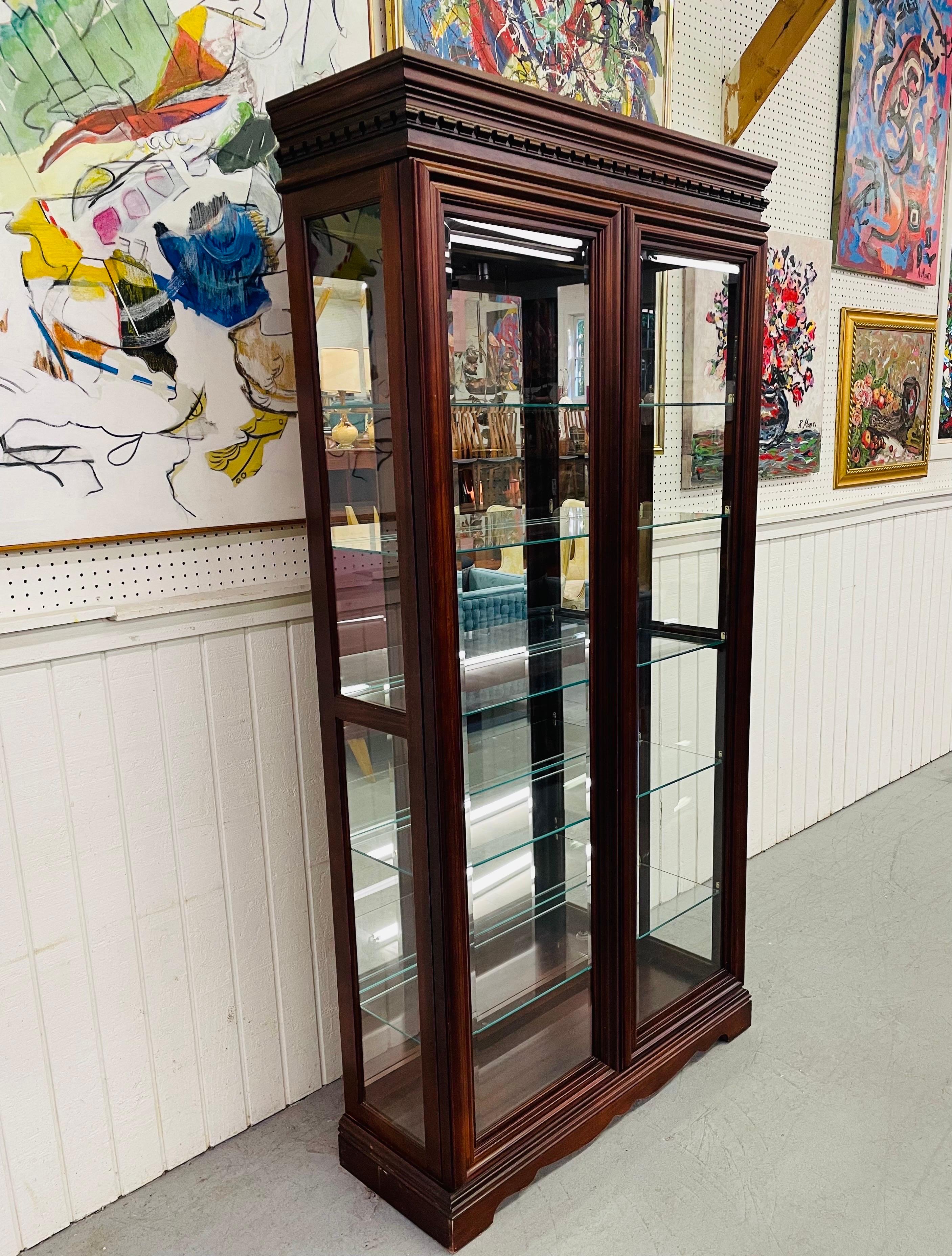 This listing is for a vintage Pulaski Mahogany Display Cabinet. Featuring sliding doors that open up to five glass shelves, a mirrored back, lighted interior, and a beautiful mahogany finish.