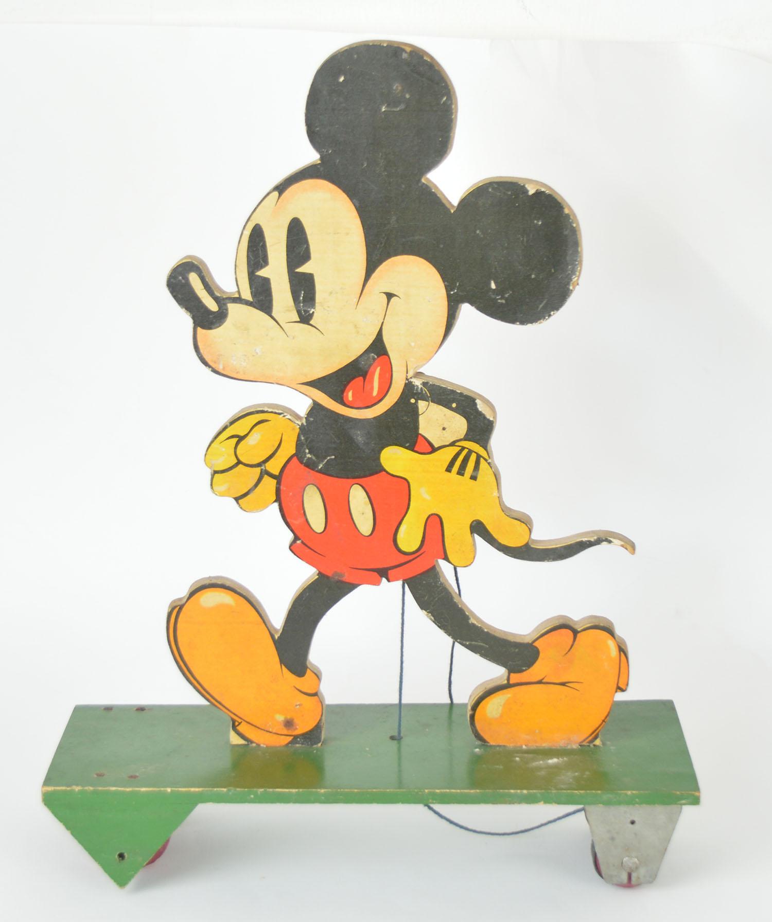 Lovely mickey mouse toy figure.

Pull along on wheels.

Printed paper on wood and painted wood. Minor chips to the paper.

One of the triangular pieces of wood on the under carriage was missing. It has been replaced with a new piece.

Free
