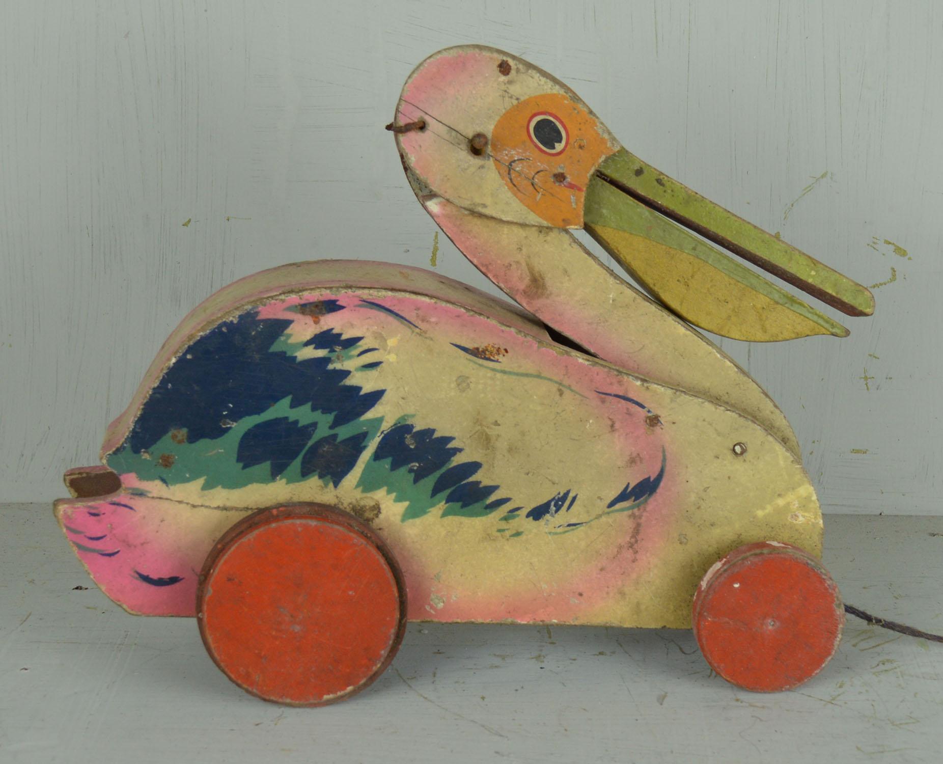 Charming little painted wood pelican toy.

The head moves and beak opens when pulled along.

Original paint.