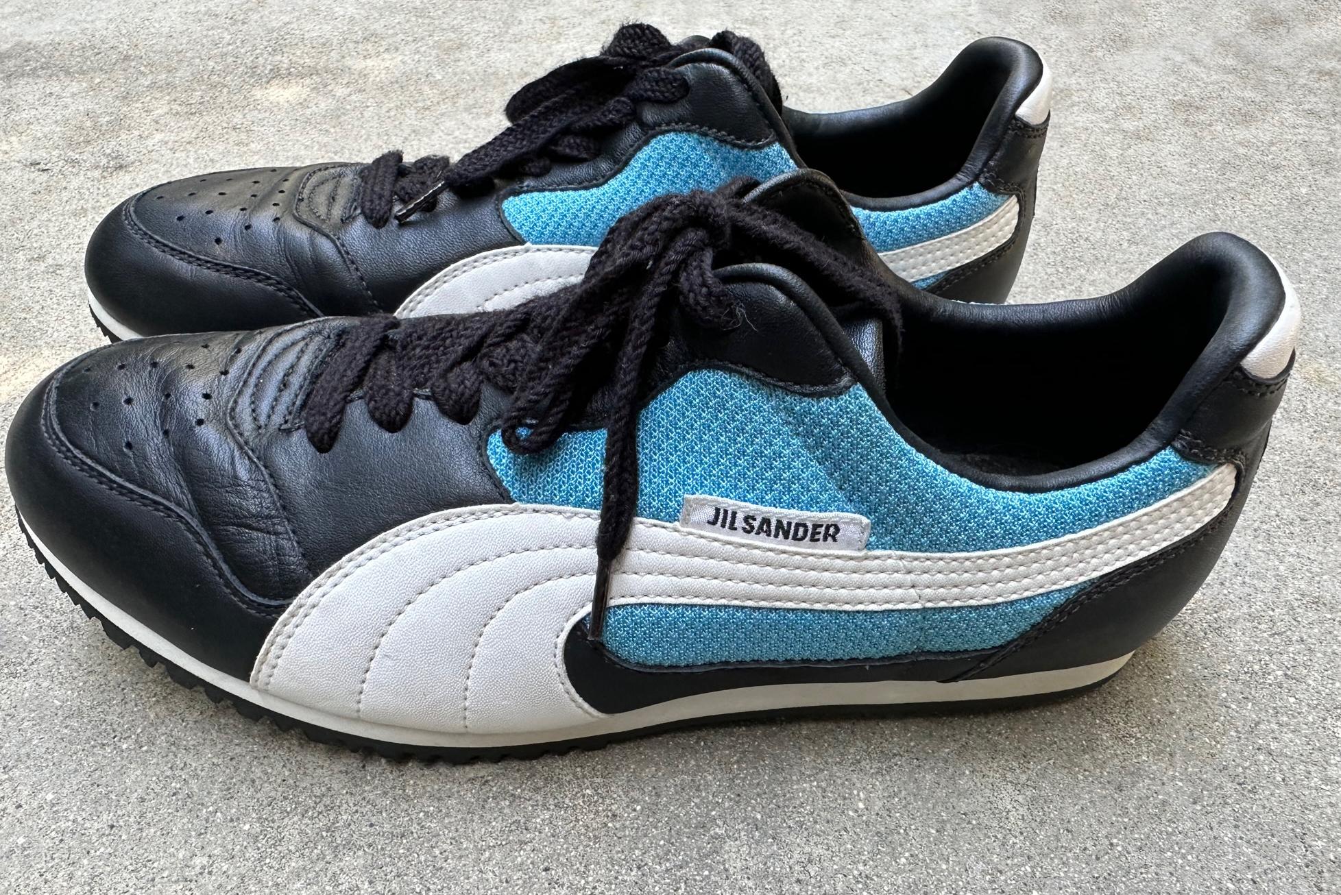 Vintage Puma Jil Sander Tennis Shoes in fantastic condition. Women’s size 9 shoe
Retro style comfortable slim fit.  Exceptionally clean J​​il Sander Women’s shoe for Puma in Navy blue leather with classic white Puma strip on the sides, decorative