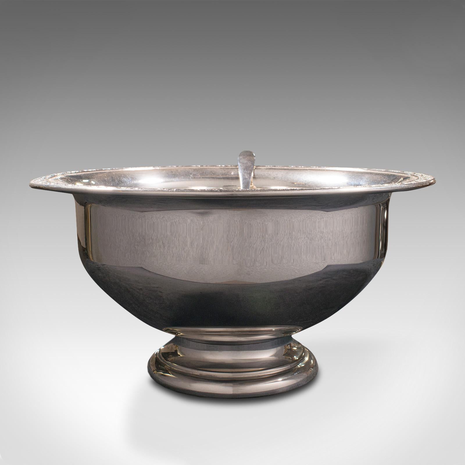 This is a vintage punch bowl. An American, silver plate serving dish with spoon, dating to the mid 20th century, circa 1950.

Wonderfully reflective with charming appearance
Displays a desirable aged patina throughout
Polished silver plate