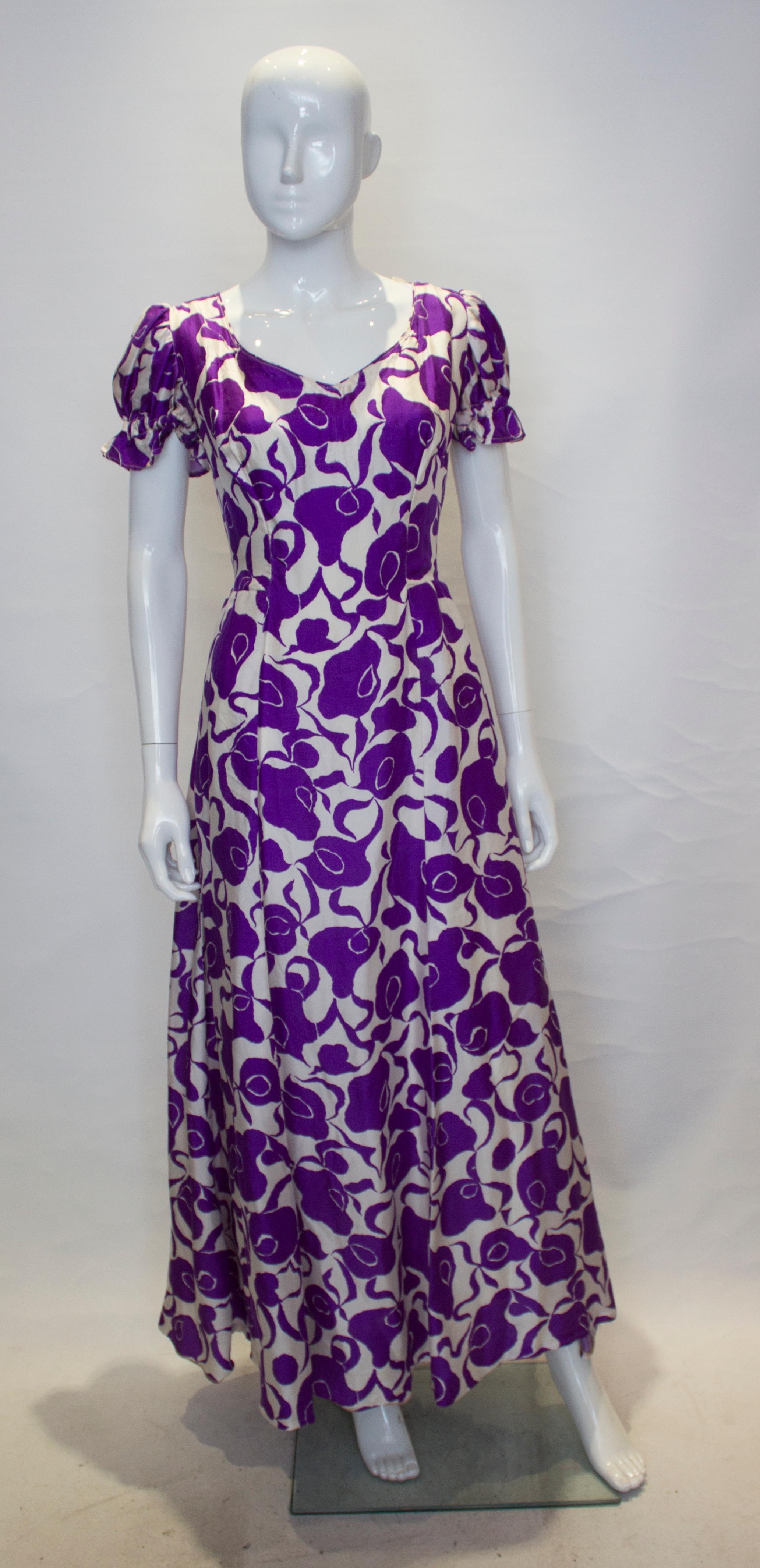 A pretty purple and white silk gown with a v neckline front and back . The dress has a central back zip, puff sleaves and is fully lined.