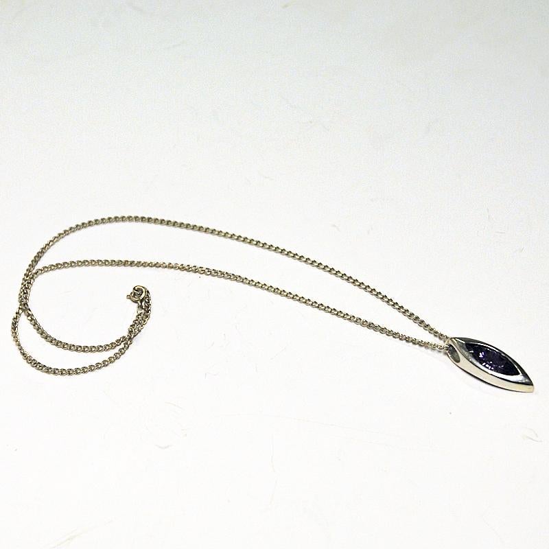 Beautiful and shiny purple stone silver necklace made by Anderssons Gravyr & Guldsmedsverk in Sweden 1960s. The ovalshaped stone is of brilliant cut rock crystal and has a light lilac lovely color. Surrounded by a solid silver frame and a silver