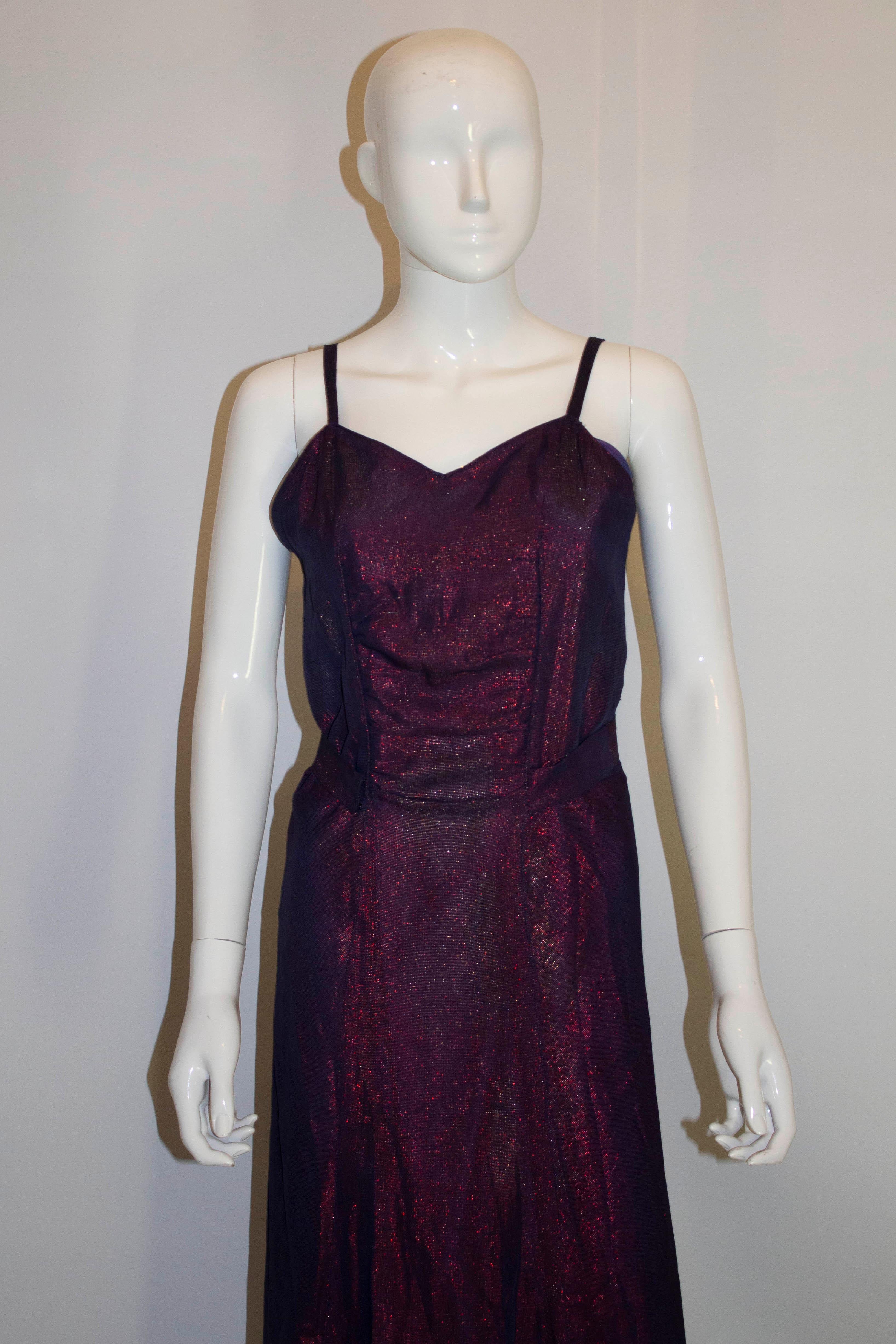 A great vintage evening gown in a pretty purple colour. The dress has a v neckline and backline, with side opening with hooks and eyes. It has a self fabric half belt at the back and is fully lined.