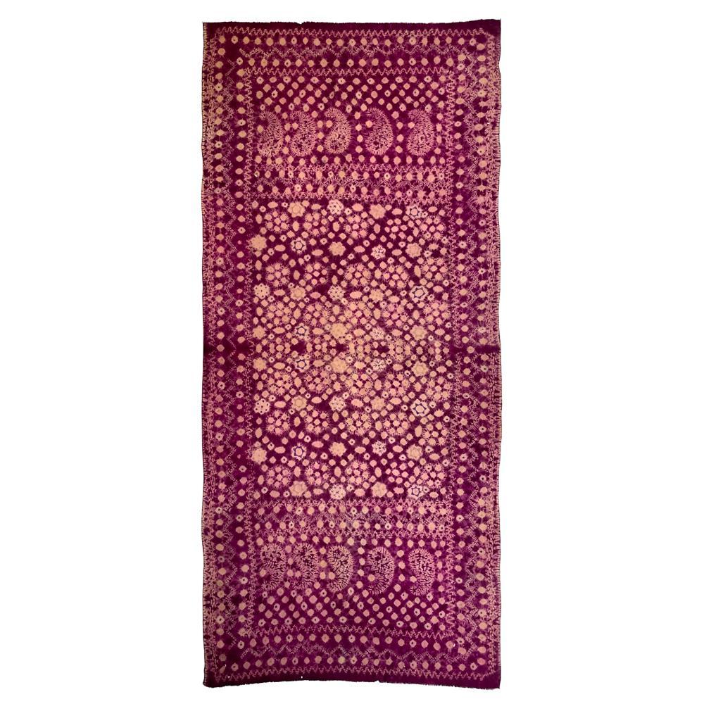 A rectangular lightweight silk textile with traditional Palembang decoration by means of plangi (rainbow tie-dye) and tritik (stitched and gathered resist) processes in one dye lot of purple in floral designs, geometric forms and five boteh shapes