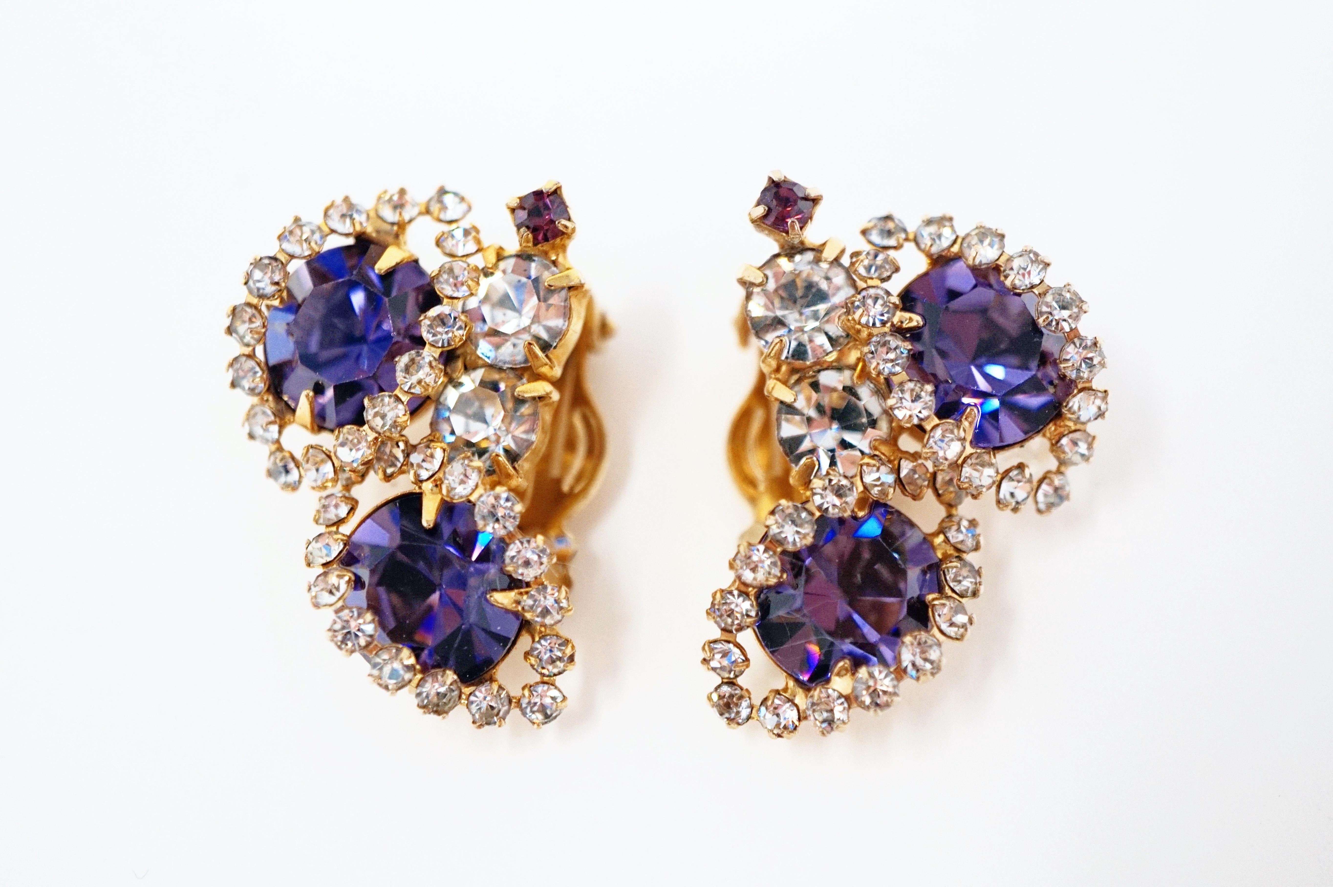 Absolutely gorgeous sparkling rhinestone earrings from the mid-century era, featuring faceted purple crystal rhinestones surrounded by clear crystal rhinestone pavé with gold tone hardware.

DETAILS:
- Clip-on earring backs
- Each earring measures
