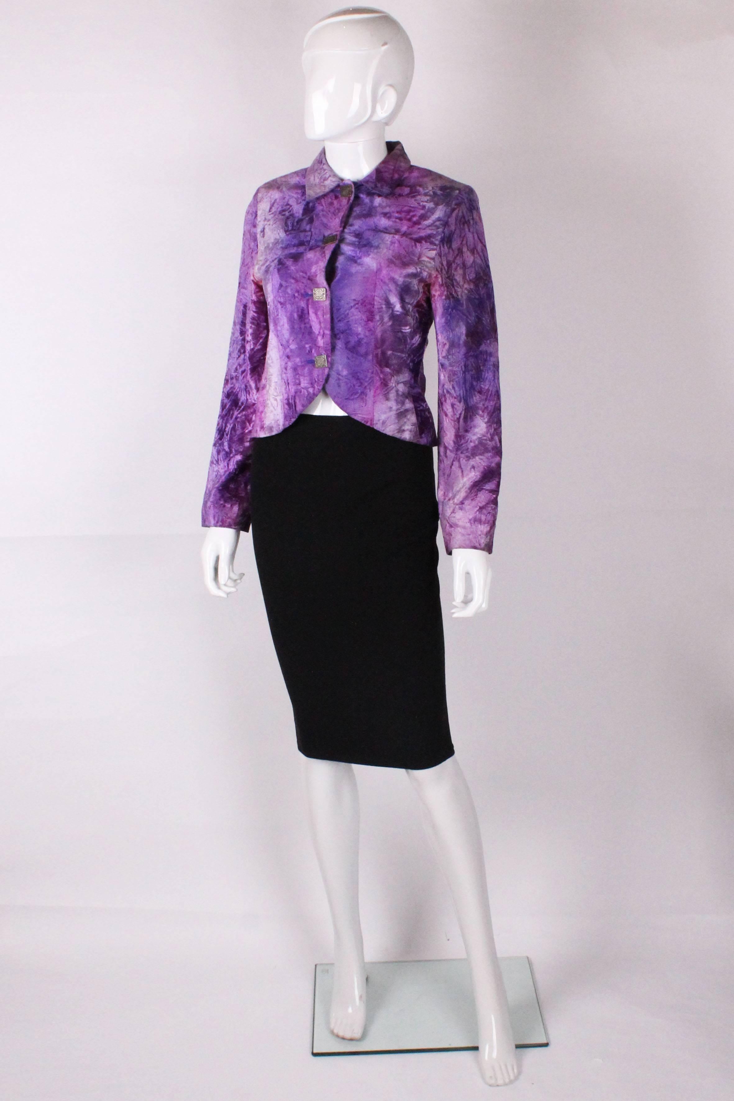 A great  vintage jacket by Biba. In  crushed velvet and various shades of purple with a wonderful orange lining, this jacket is a real head turner. It has 4 buttons at the front ,with cut away detail at the hem and two breast pockets.

