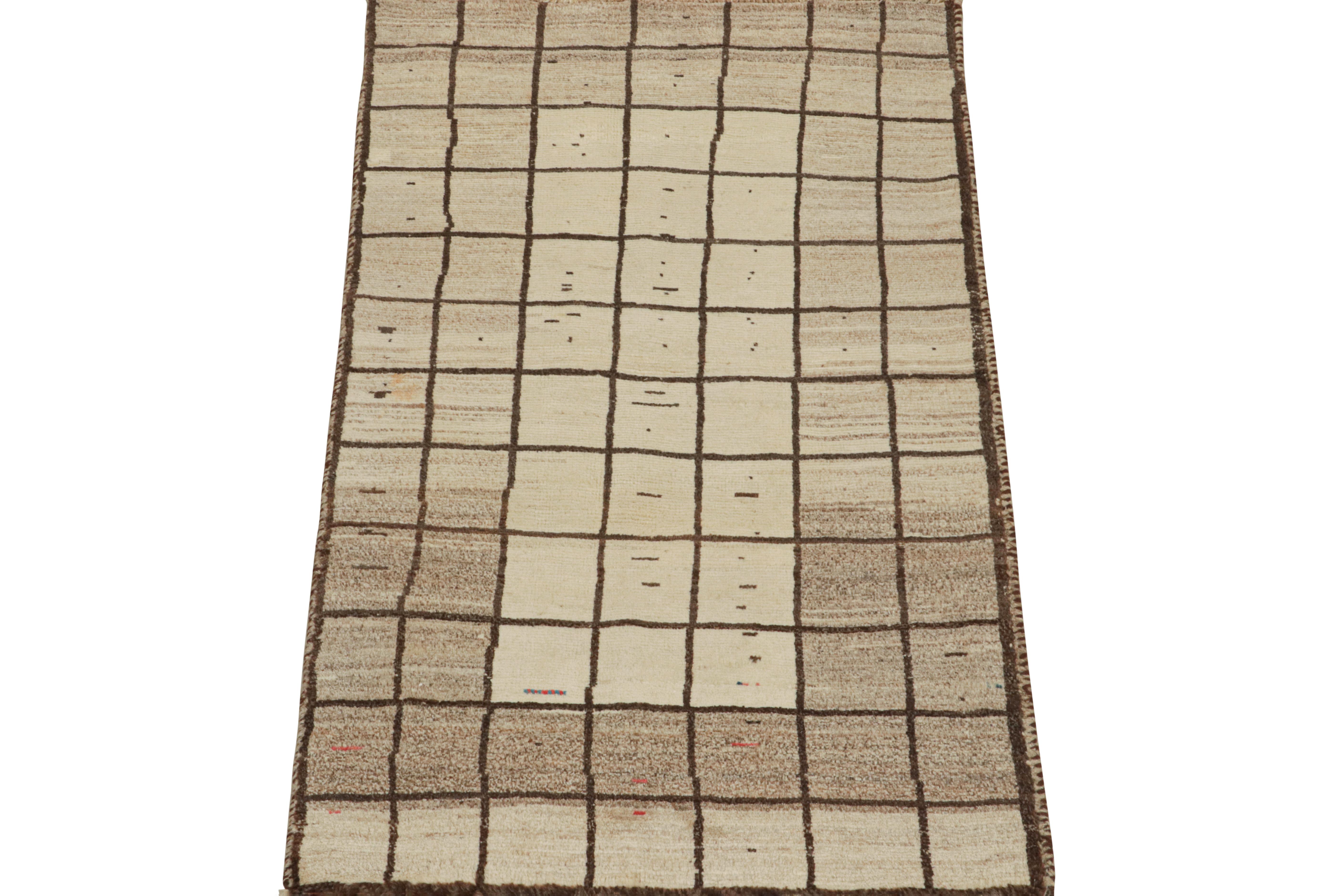 This vintage 3x6 Persian runner is a Gabbeh rug that originates from the Qashqai tribe—hand-knotted in wool circa 1950-1960.

Its geometric pattern enjoys a play of beige and brown in a grid with playful accents therein. Connoisseurs will further