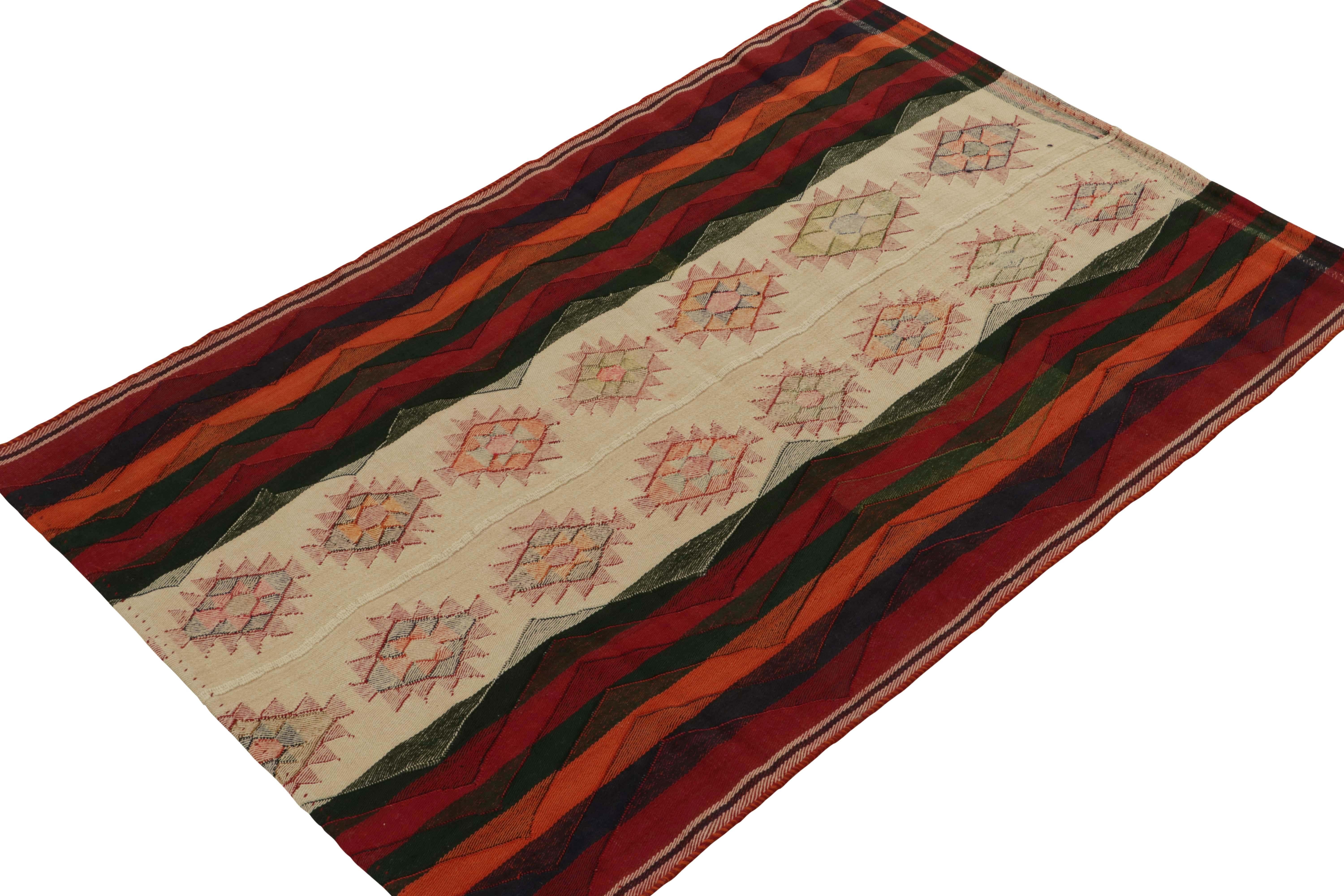 An extremely collectible vintage Persian Kilim of Qashqai provenance, handwoven in wool circa 1950-1960. 

This tribal rug enjoys an uncommon marriage of nomadic elements—including a narrow field in brighter colors between richer stripes. A beige