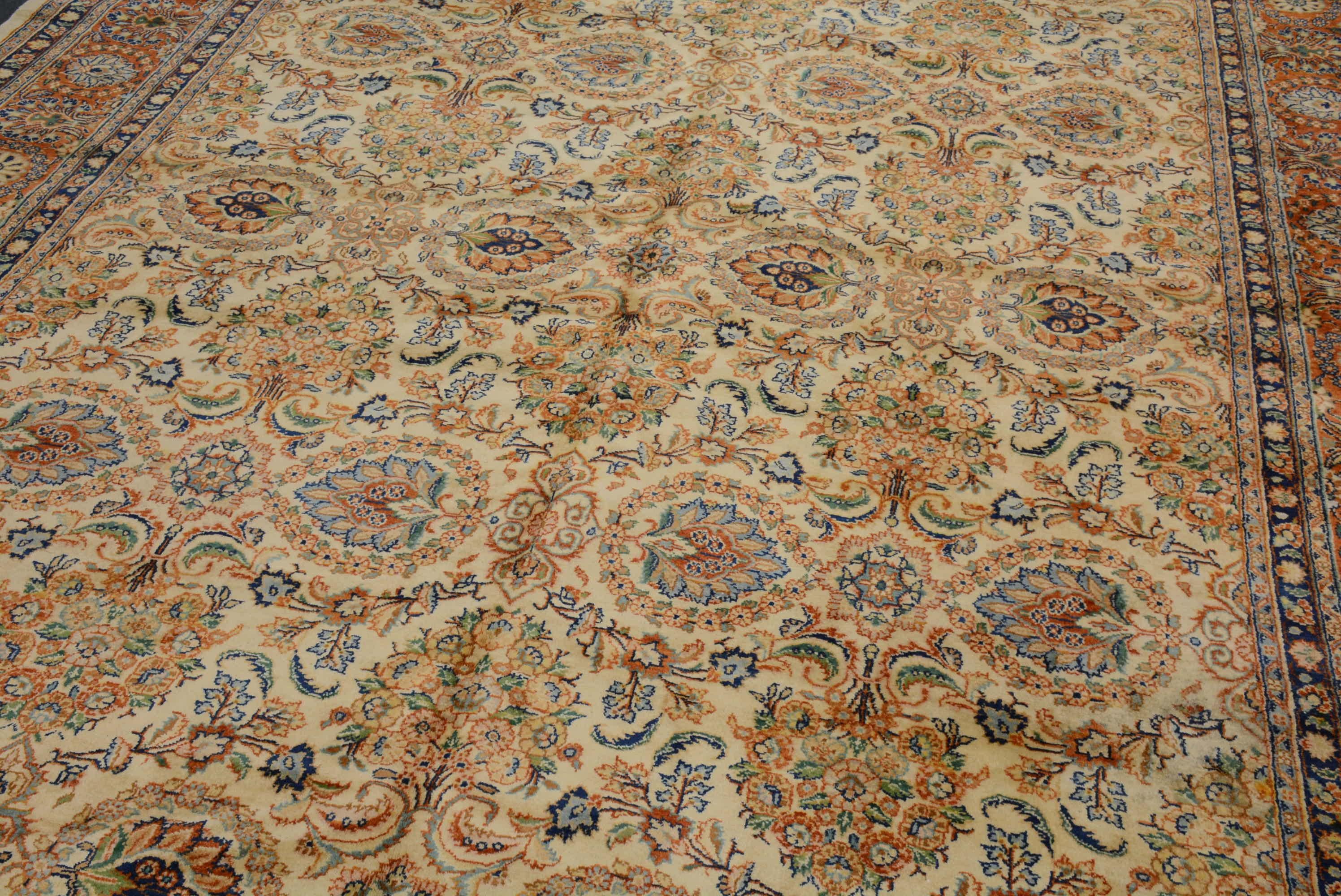 Tappeto Qazvin della metà del XX secolo proveniente dall'Iran centrale con un motivo floreale complessivo su un campo avorio all'interno di un bordo floreale color ruggine.  15' 11