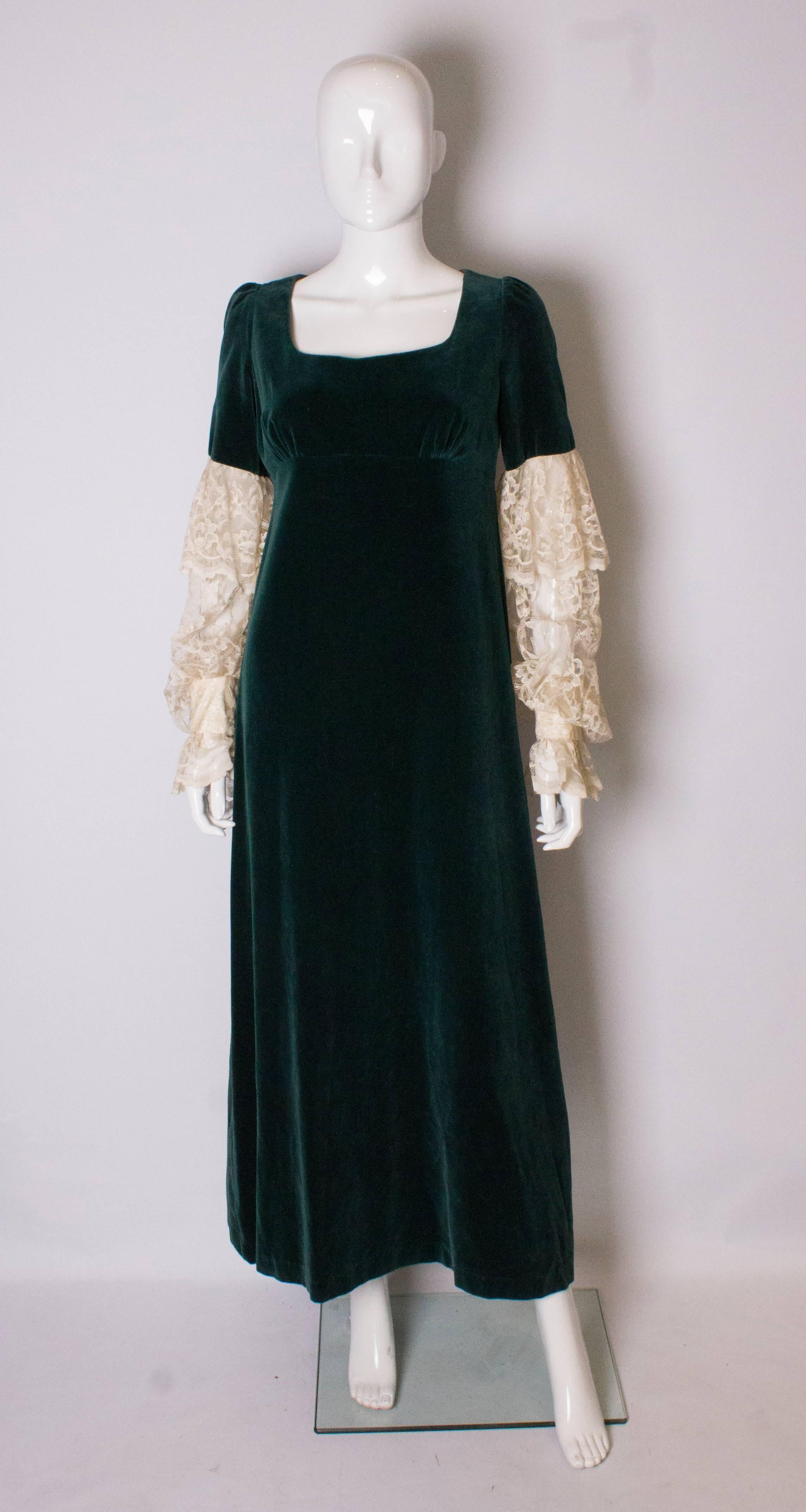 A great vintage  gown by Quad.  The body of the dress is in green velvet  with a low scoop neck, and short sleeves. The rest of the sleeves are white lace with 2 popper cuffs. The dress is fully lined.