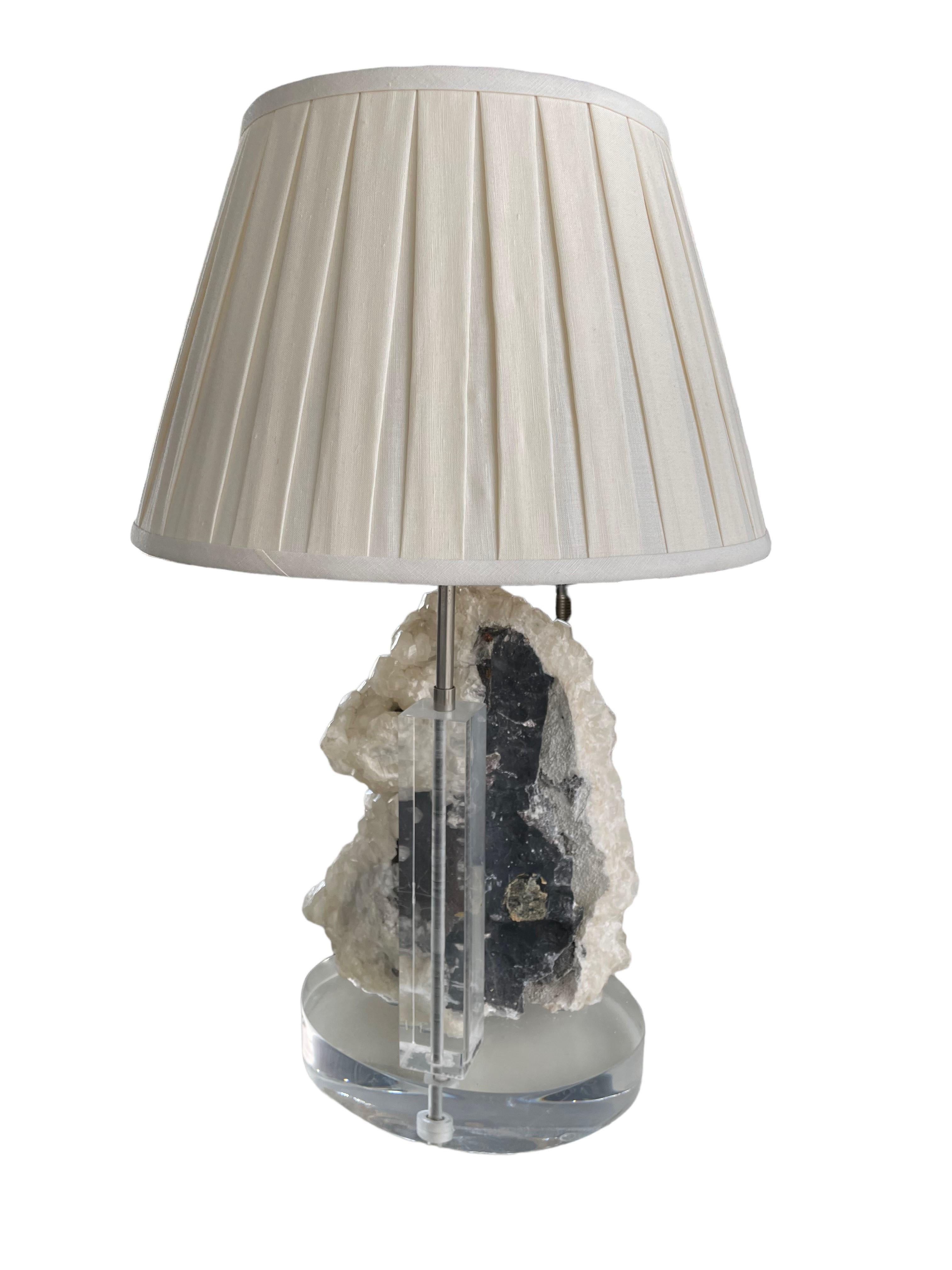 Quartz, as one of the hardest and strongest minerals on earth, makes a strong statement! This application, as a lamp, further highlights the lustrous combination of the crystals’ sparkle and matte composition. The Lucite base and finial paired with