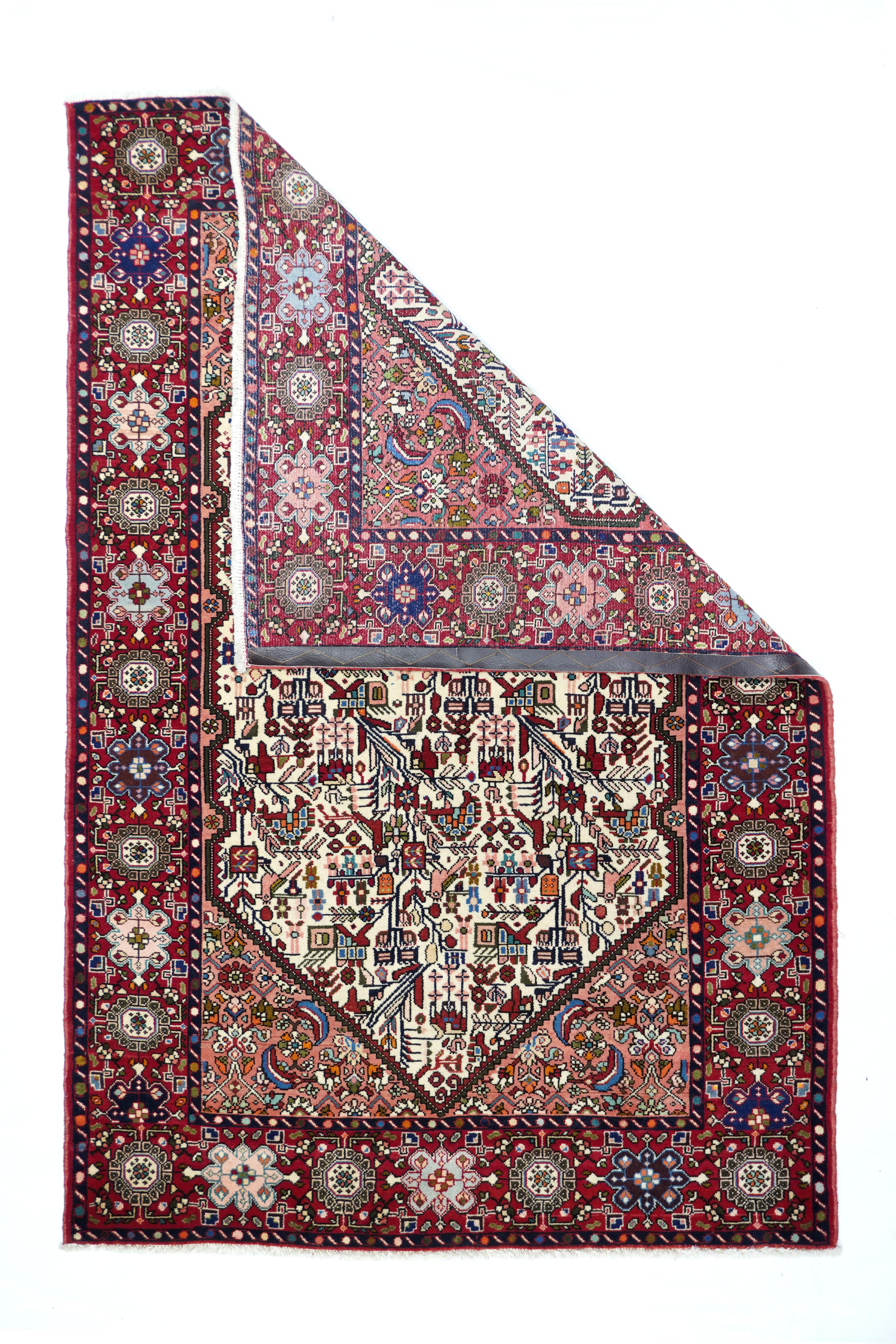 Vintage Quashkai rug 4'3'' x 6'5''. The indented pointed ivory hexagonal subfield displays leaves, flowers and oblique vines in a semi-geometric manner on this well-woven asymmetrically knotted, cotton foundation scatter. The light rose ground shows