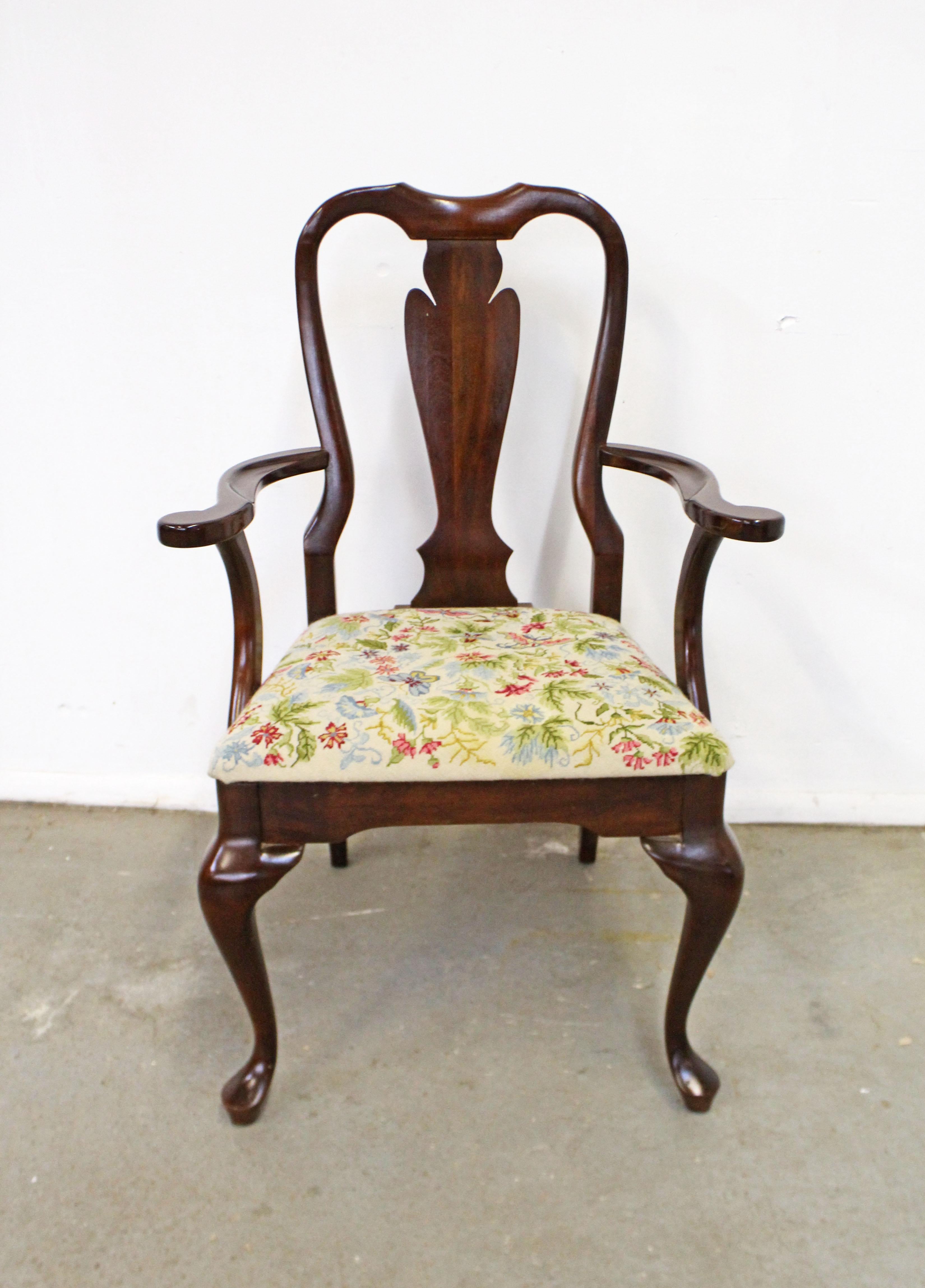 Offered is a vintage Queen Anne arm chair. It's made of solid cherry wood and has a beautifully stitched floral upholstered seat. In good condition for its age, with some slight surface scratches/wear on the wood. The upholstery is in good