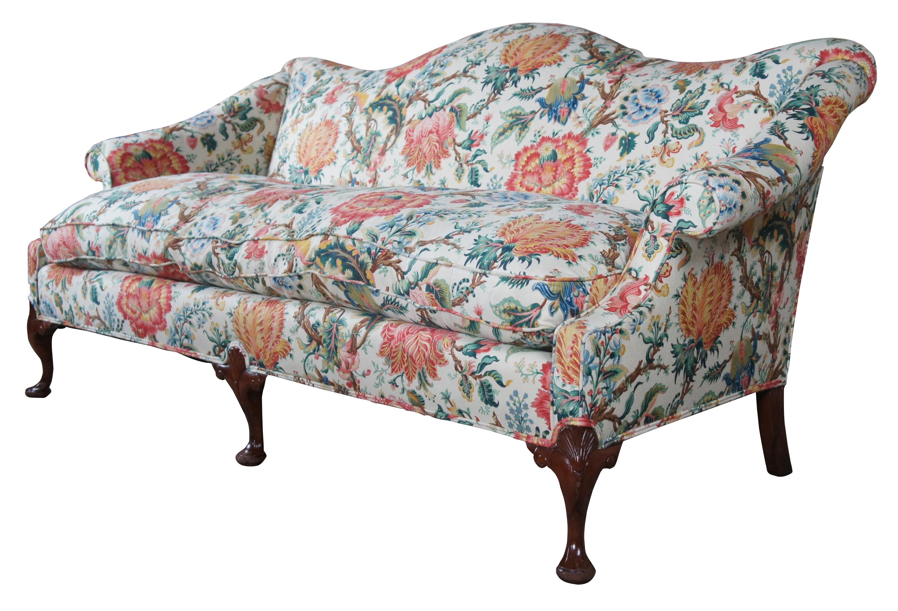 An exquisite Queen Anne style camelback settee or sofa, circa mid-20th century. Features a beautiful swooping back, rolled arms and large removable down filled seat. The settee is supported by cabriole legs with scallop carved knees, scrolling