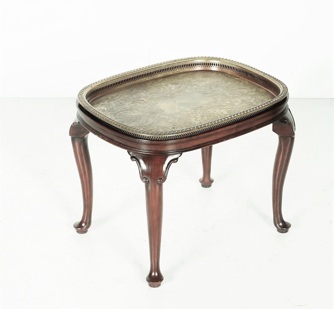 A vintage Queen Anne style mahogany tray top side table. This table features a rectangular top with rounded corners and raised, molded edges. A removable brass tray with raised pierced edges can be placed on top. The brass tray has an ornate floral