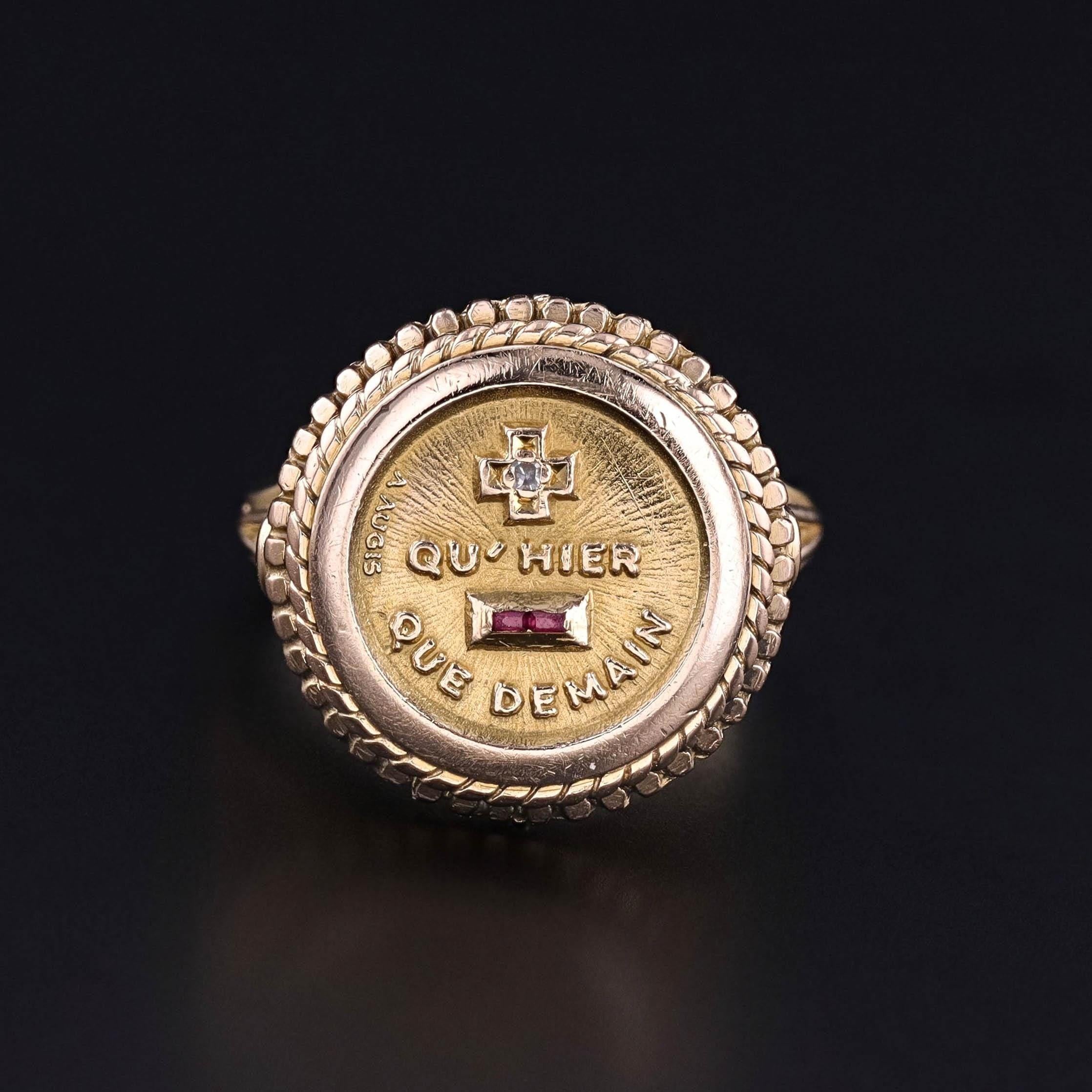 Vintage Love Poem Ring: This vintage ring (circa 1970) features a diamond plus, a ruby minus, and the French quote 'Qu'hier Que Demain' which translates to 
