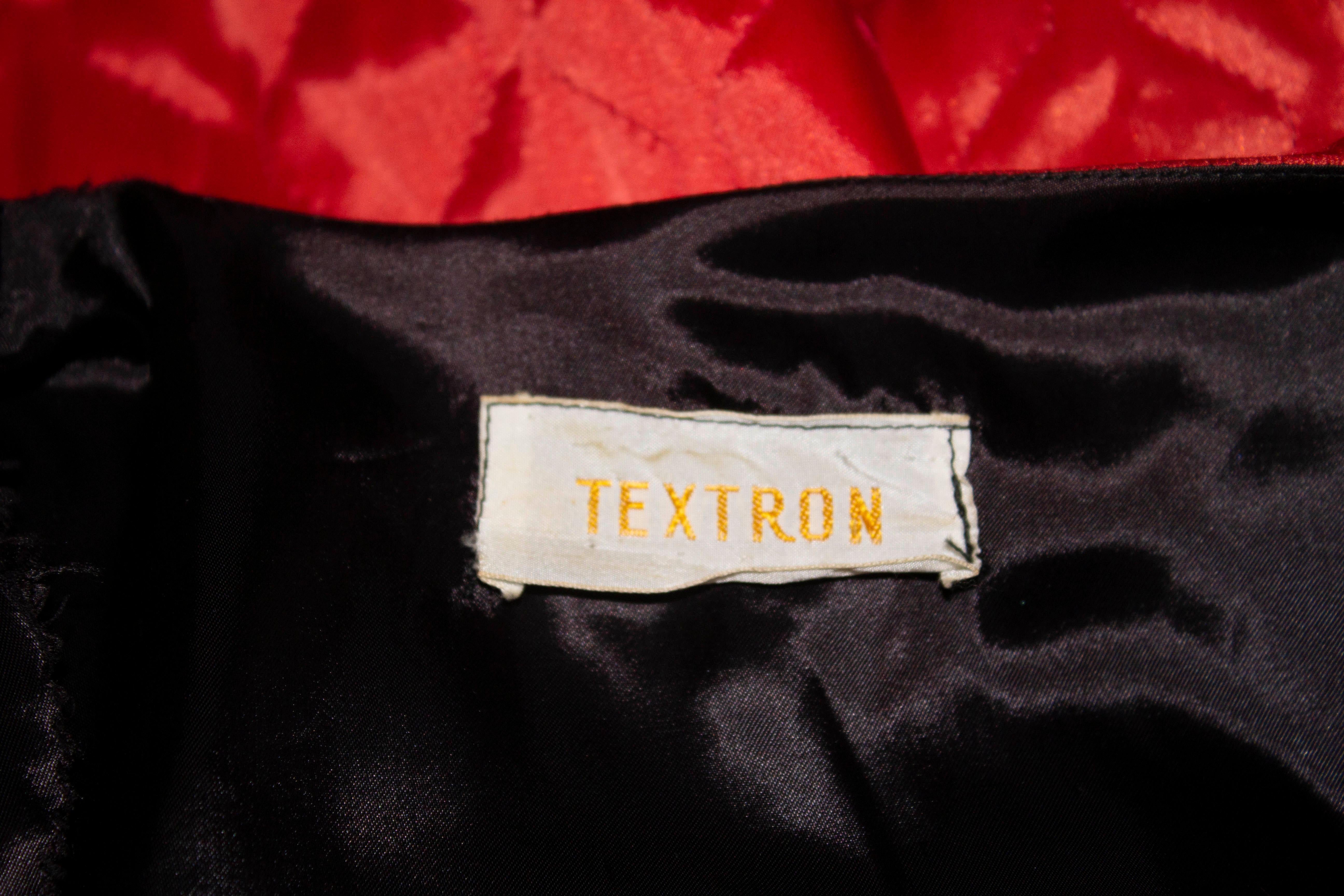 A fun vintage jacket by Textron. The jacket is in a red quilted fabric with black detail on each side.  There is one patch pocket and x '' slit on either side. The jacket is fully lined and has the original shoulder pads.