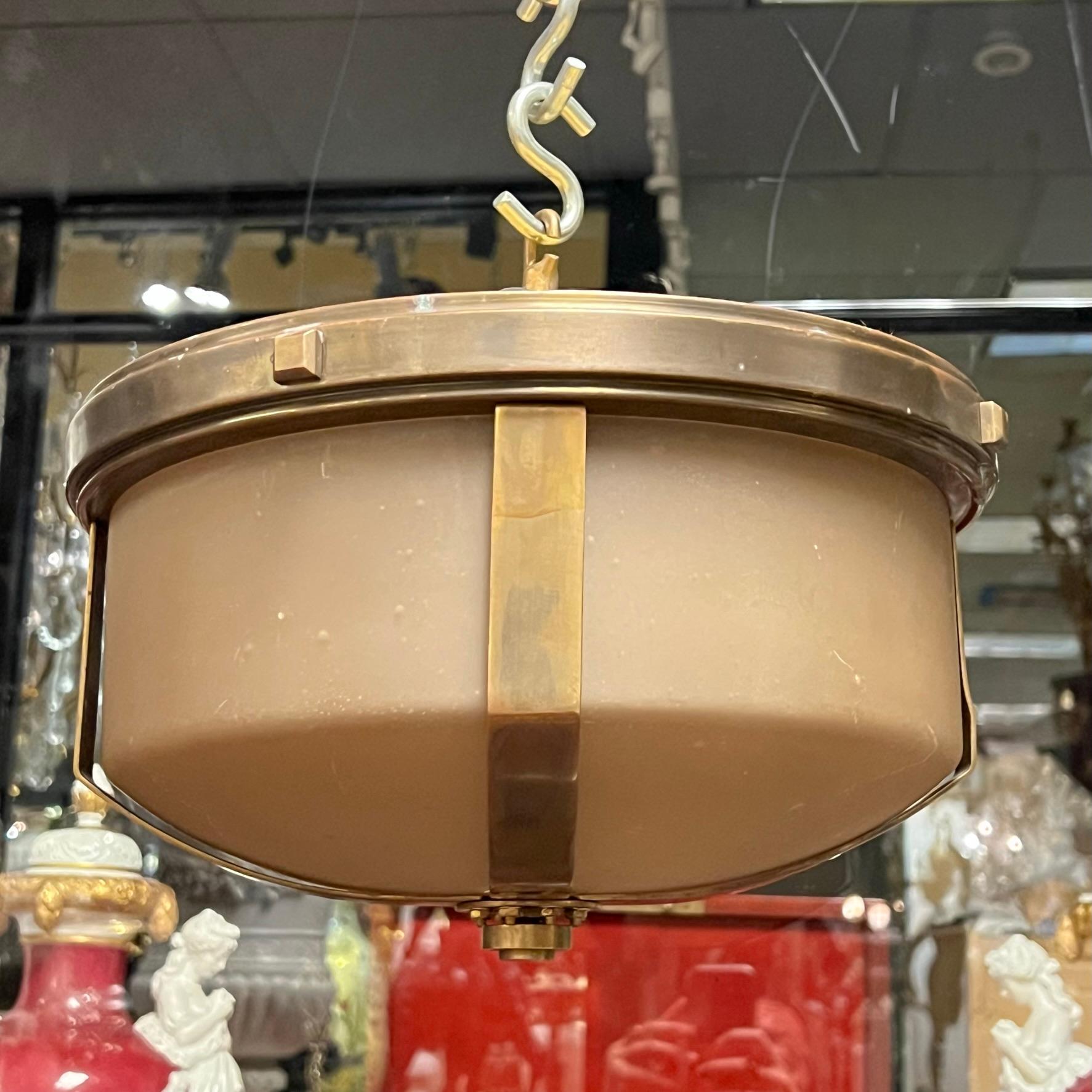 Vintage metal chandelier in the industrial, machine age style with bronze patina and taupe colored glass shade by Quoizel. Wired and ready for use.