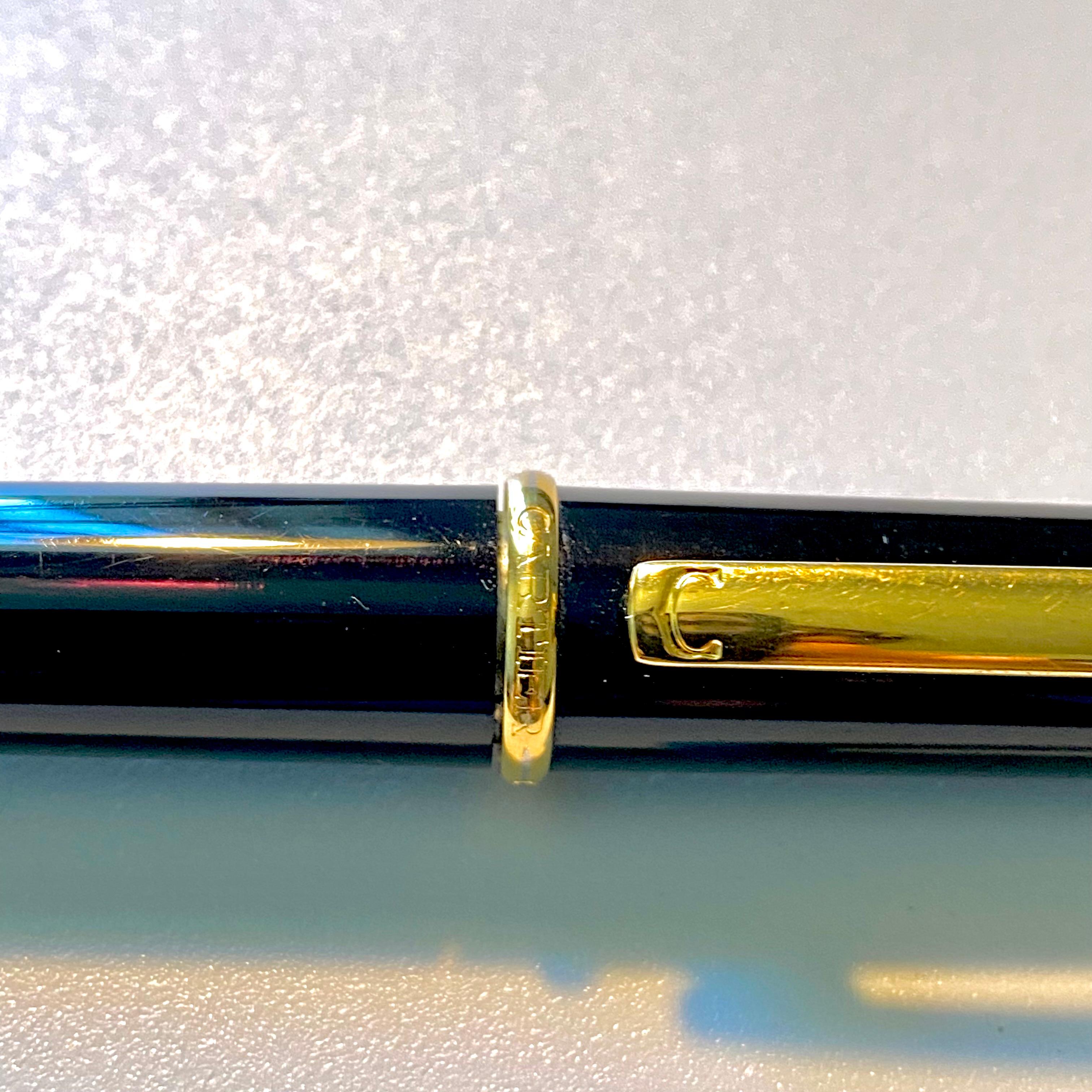 R de Cartier ballpoint pen in black composite, golden-finish details, blue resin cabochon. 
Dimension: 140 mm high, 0.40 