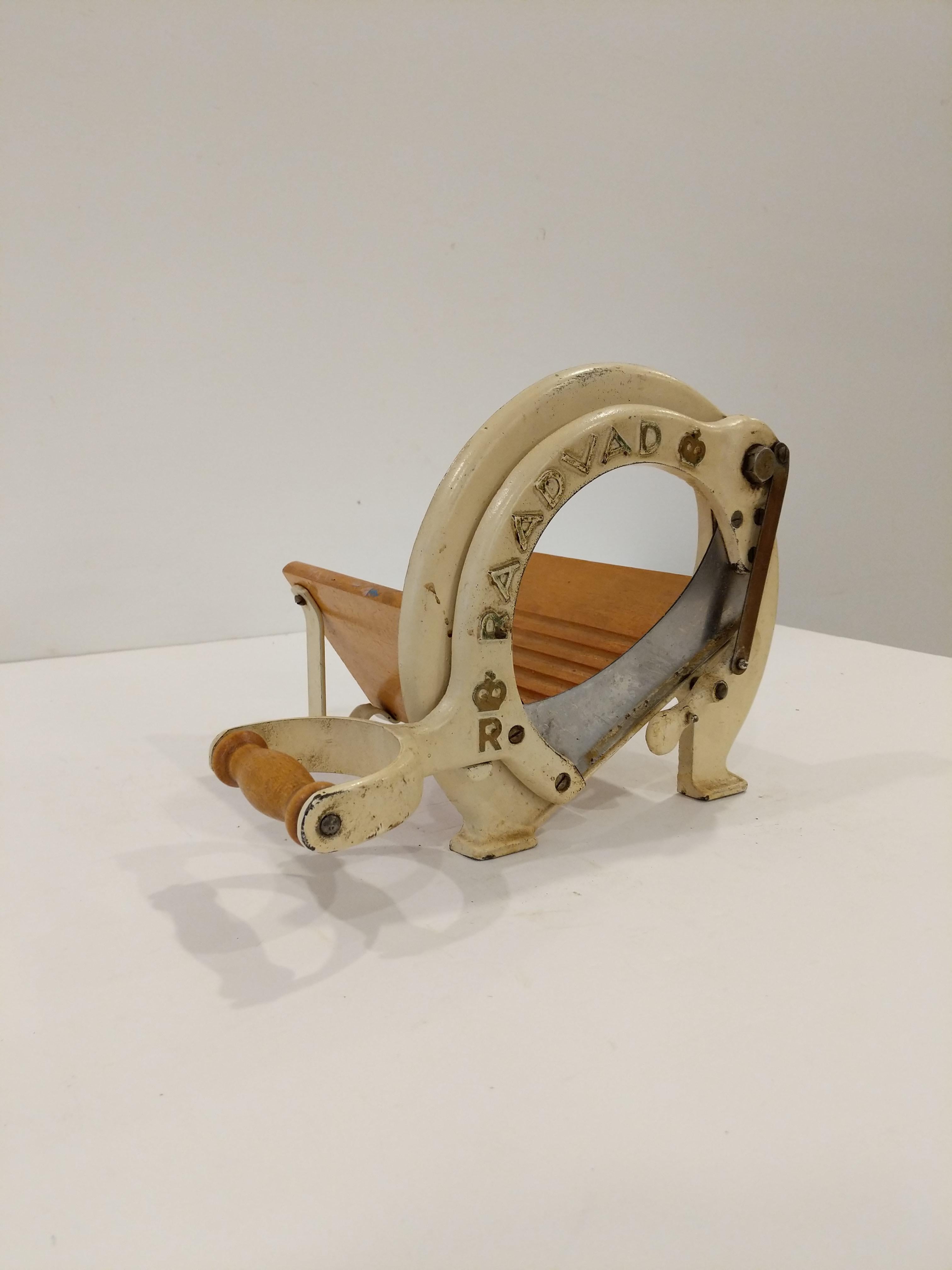 Authentic vintage Danish bread slicer / guillotine in cream with gold lettering.

Model 294 by Raadvad.

This slicer is in good condition overall and expectedly shows its age a bit.

Dimensions:
13.5” Long including handle
9.5” Tall
8” Wide

Ref: