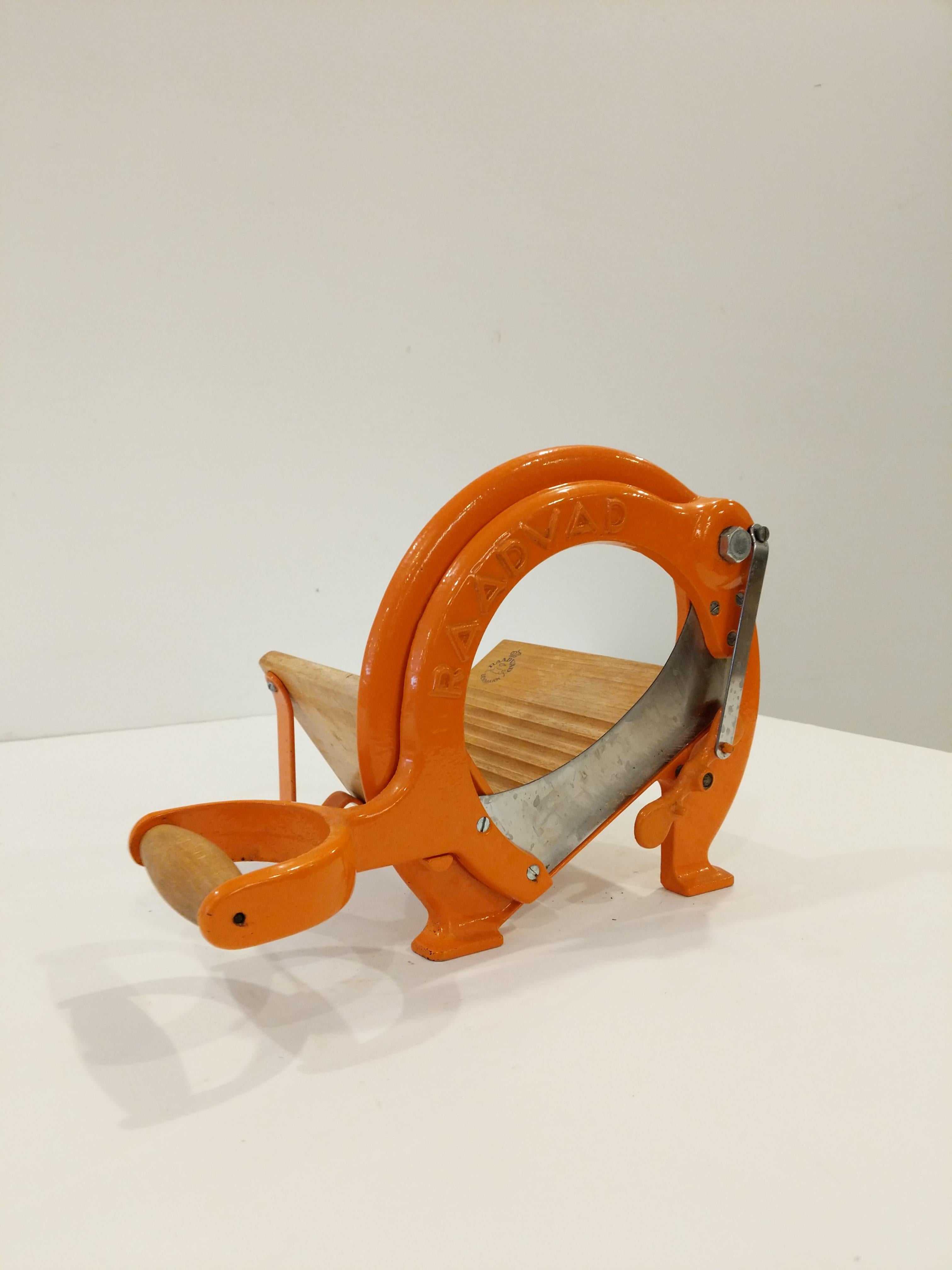 Authentic vintage Danish bread slicer / guillotine in orange.

Model 294 by Raadvad.

This slicer is in good condition overall and expectedly shows its age a bit.

Dimensions:
13.5” Long including handle
9.5” Tall
8” Wide

Ref: RV27-009
