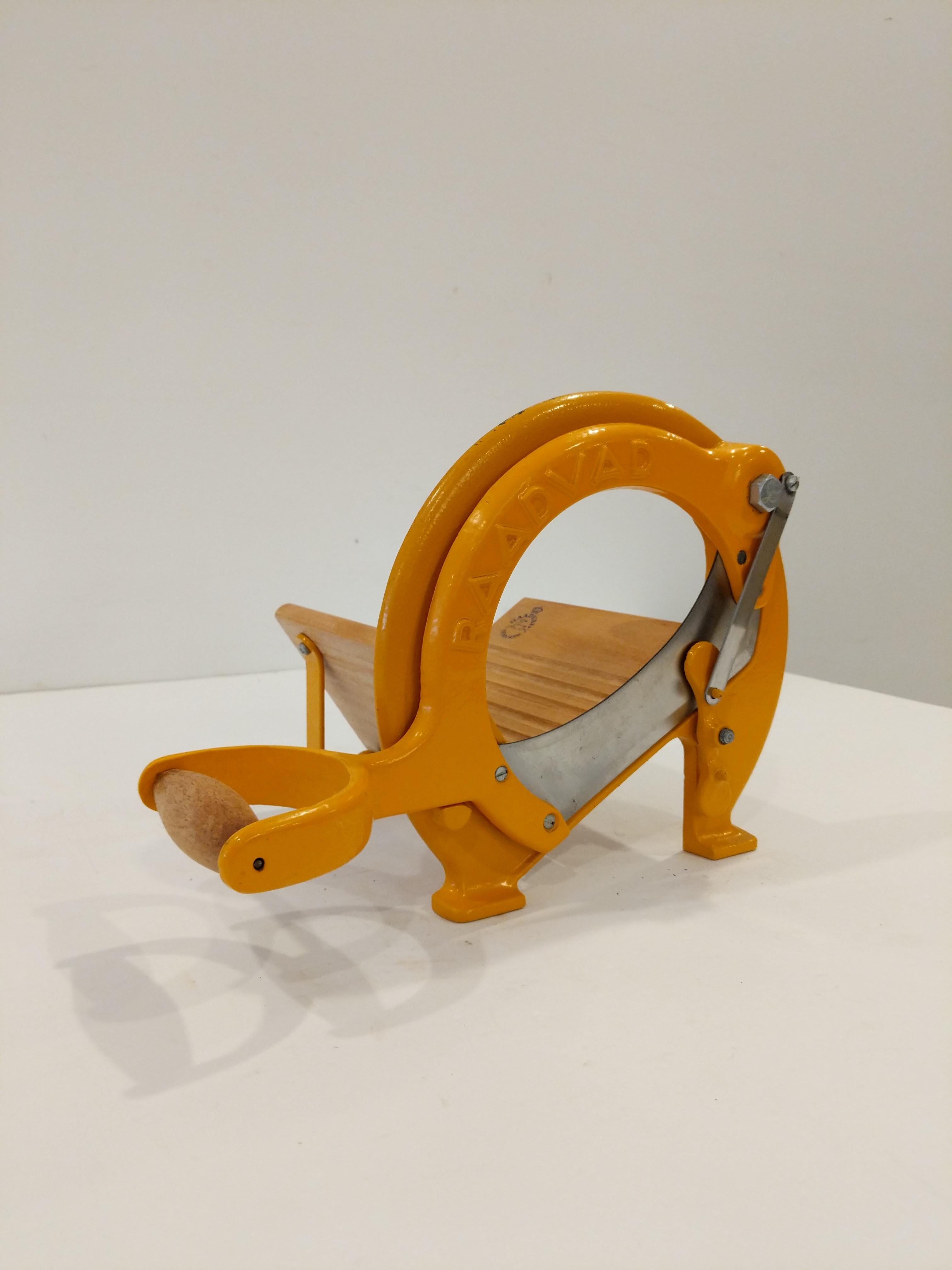 Authentic vintage Danish bread slicer / guillotine in yellow-orange.

Model 294 by Raadvad.

This slicer is in good condition overall and expectedly shows its age a bit.

Dimensions:
13.5” Long including handle
9.5” Tall
8” Wide

Ref: RV27-057