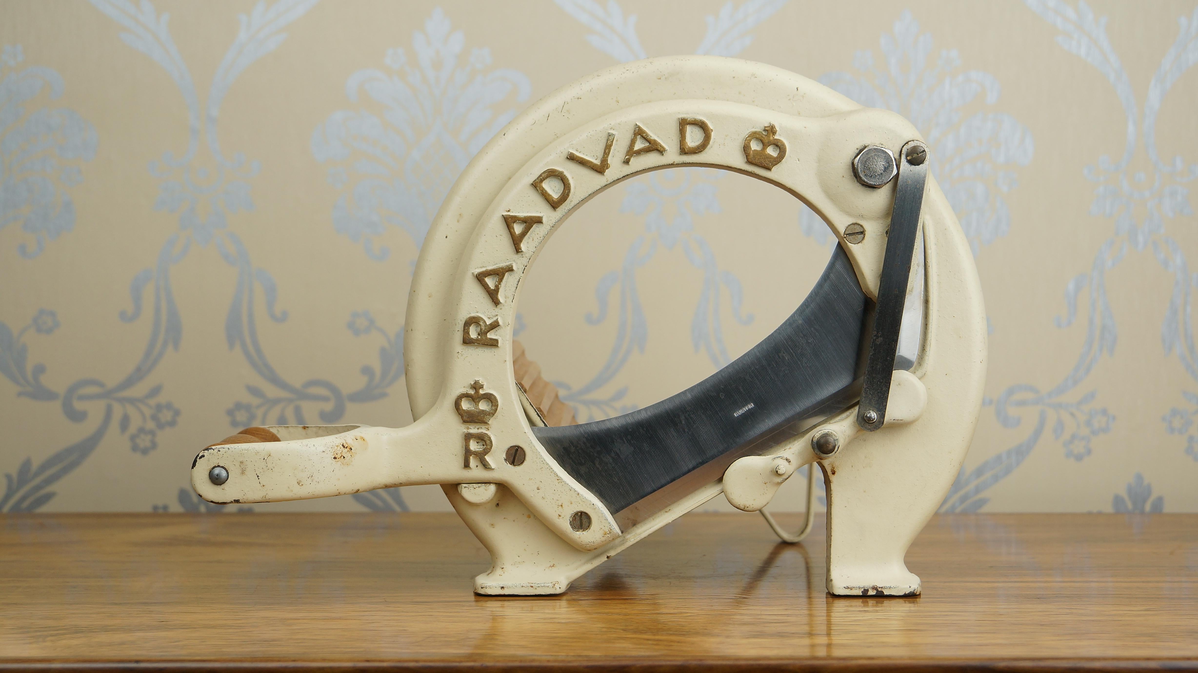 Vintage Danish cast iron bread slicer in cream, steel blade, oak handle and birch boards, designed by Ove Larsen in 1956 for Raadvad Knivfabrik , Denmark. 

The guillotine-style bread slicer was a staple of the Danish home from the 19th century,