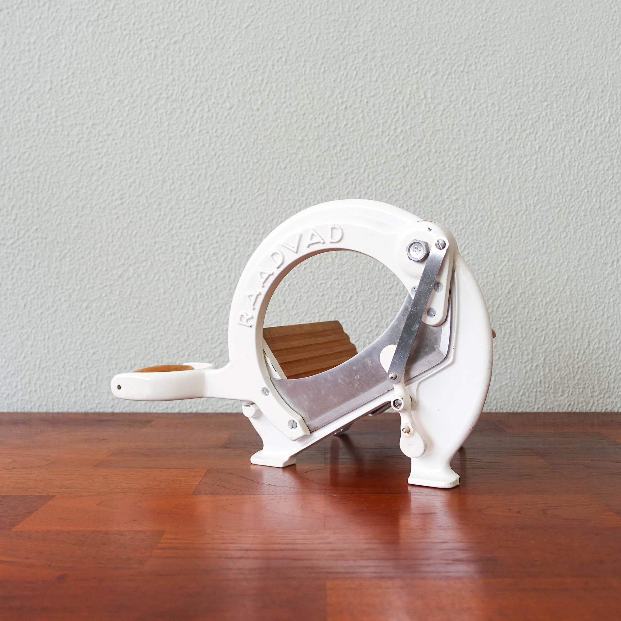 This bread slicer, model 294, was designed by Ove Larsen and produced by Raadvad in Denmark, during the 1970s. It comes with the original white lacquer. The bread slicer is fully functional for slicing bread and is at the same time very decorative.