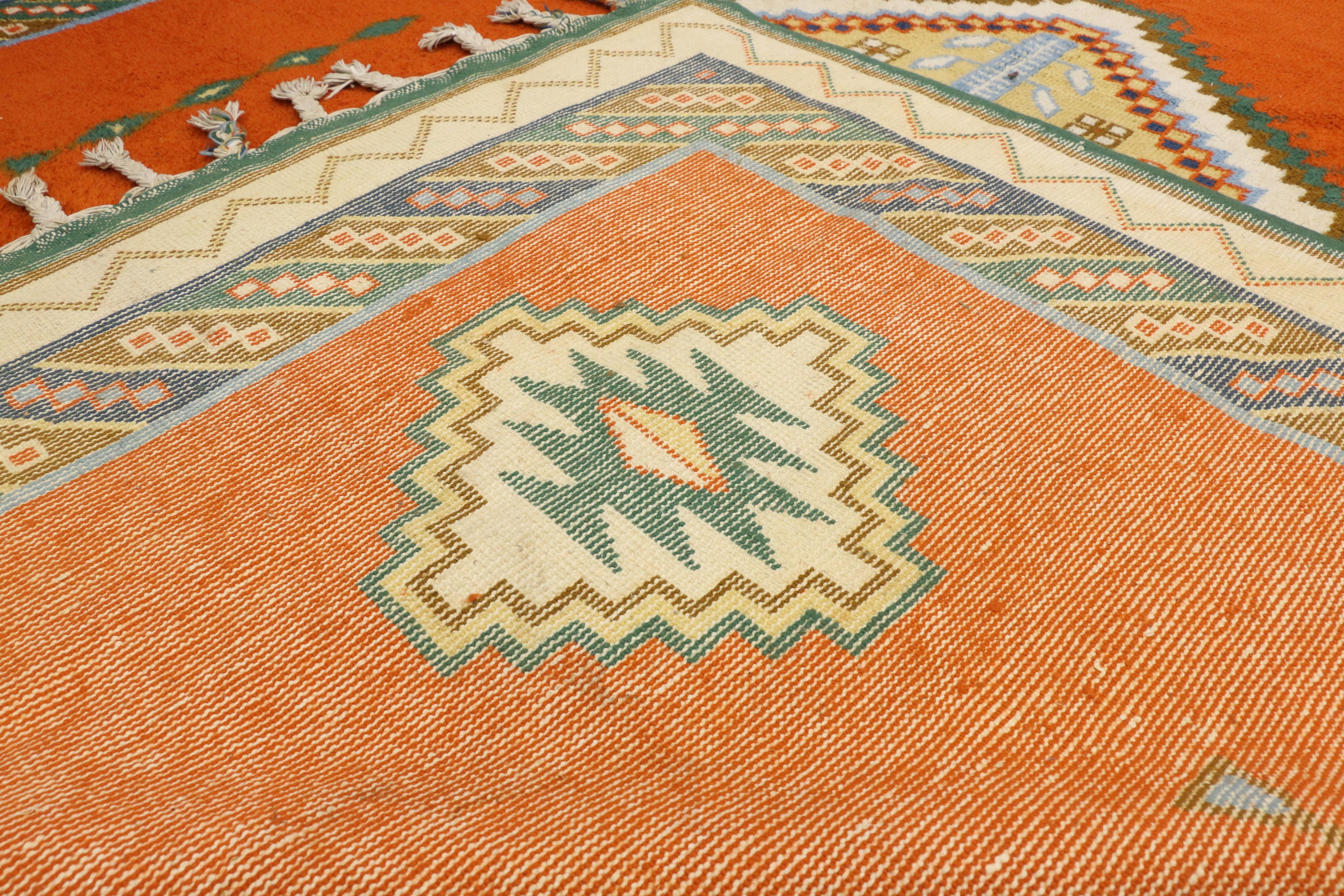 77202, Tribal style vintage Rabat Moroccan area rug, oversize rug, palace size carpet. This hand knotted wool vintage Rabat Moroccan rug features a four-and-one medallion design spread across a bright pumpkin field. The larger hooked diamond-shaped