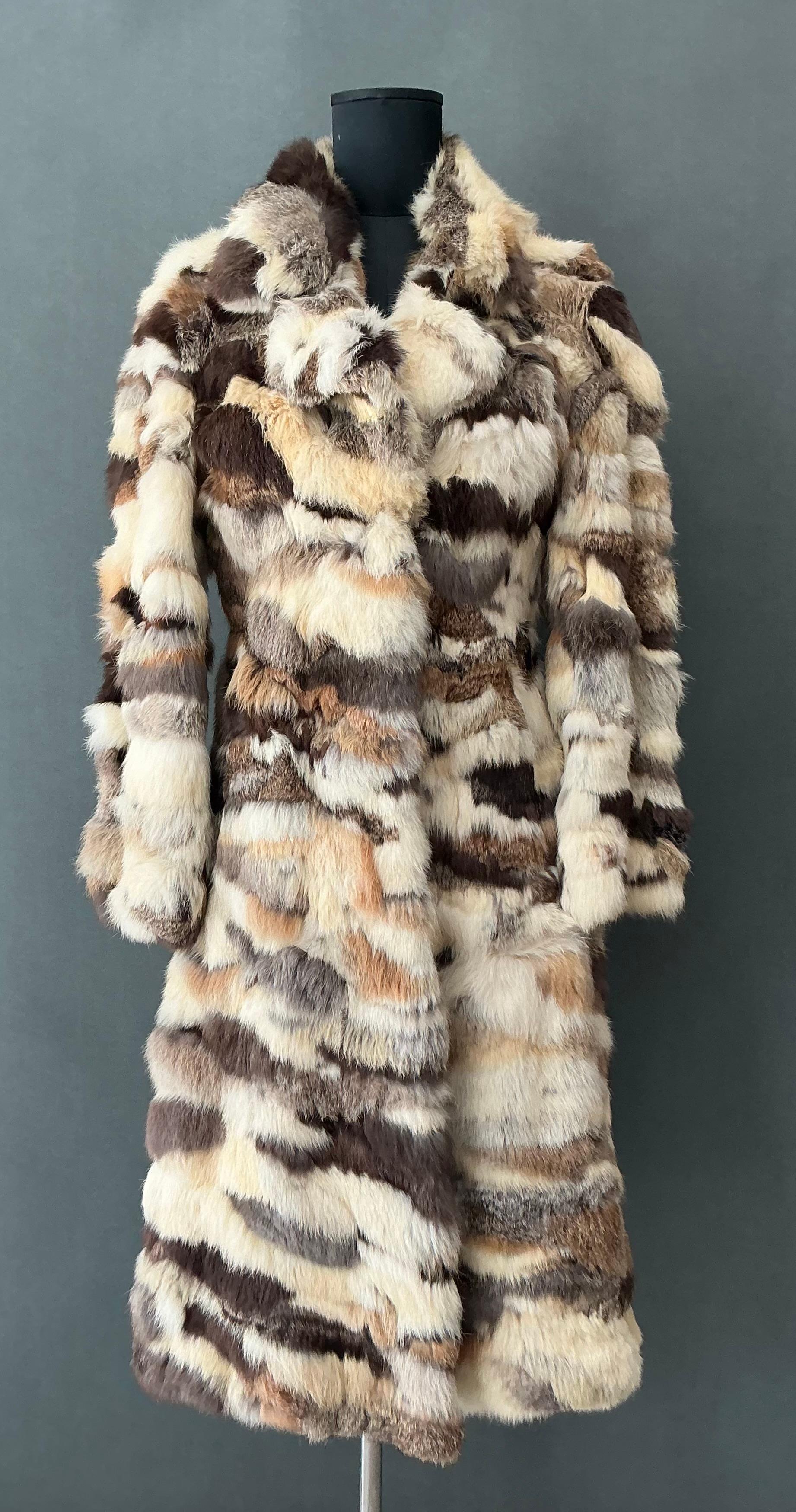 This Vintage Rabbit Fur Fully Lined Coat is a luxurious and timeless piece that brings together warmth, comfort, and elegance. The high-quality rabbit fur and silk or satin lining make it a standout item, perfect for colder months while maintaining