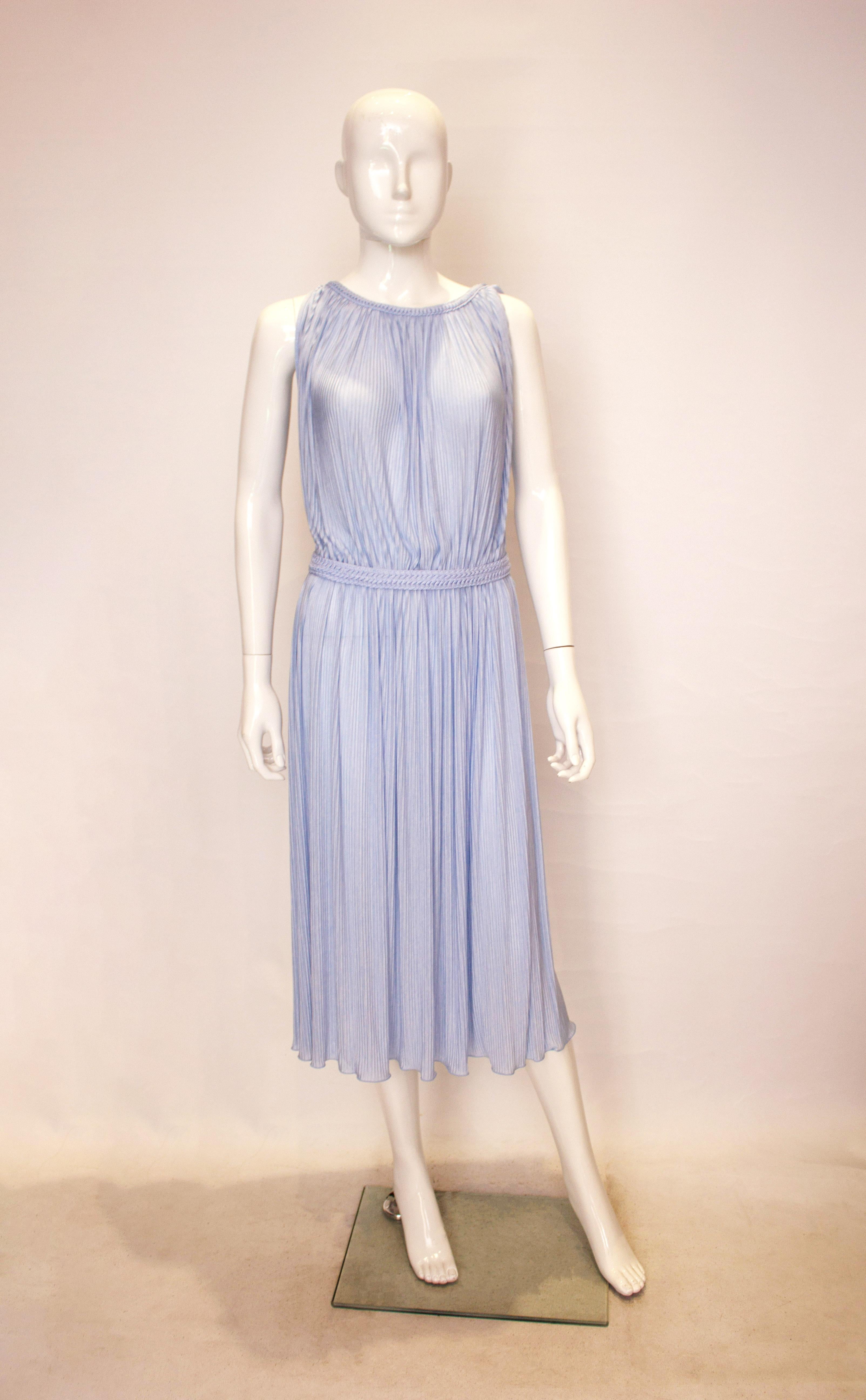 A chic vintage dress by Radley in a pretty ice blue colour.  The dress is in a pleated fabric with plait detail around the neckline , and a bow tie on the left shoulder . It has an elasticated waist and can fit a waist 26'' -32''.  It has a key hole