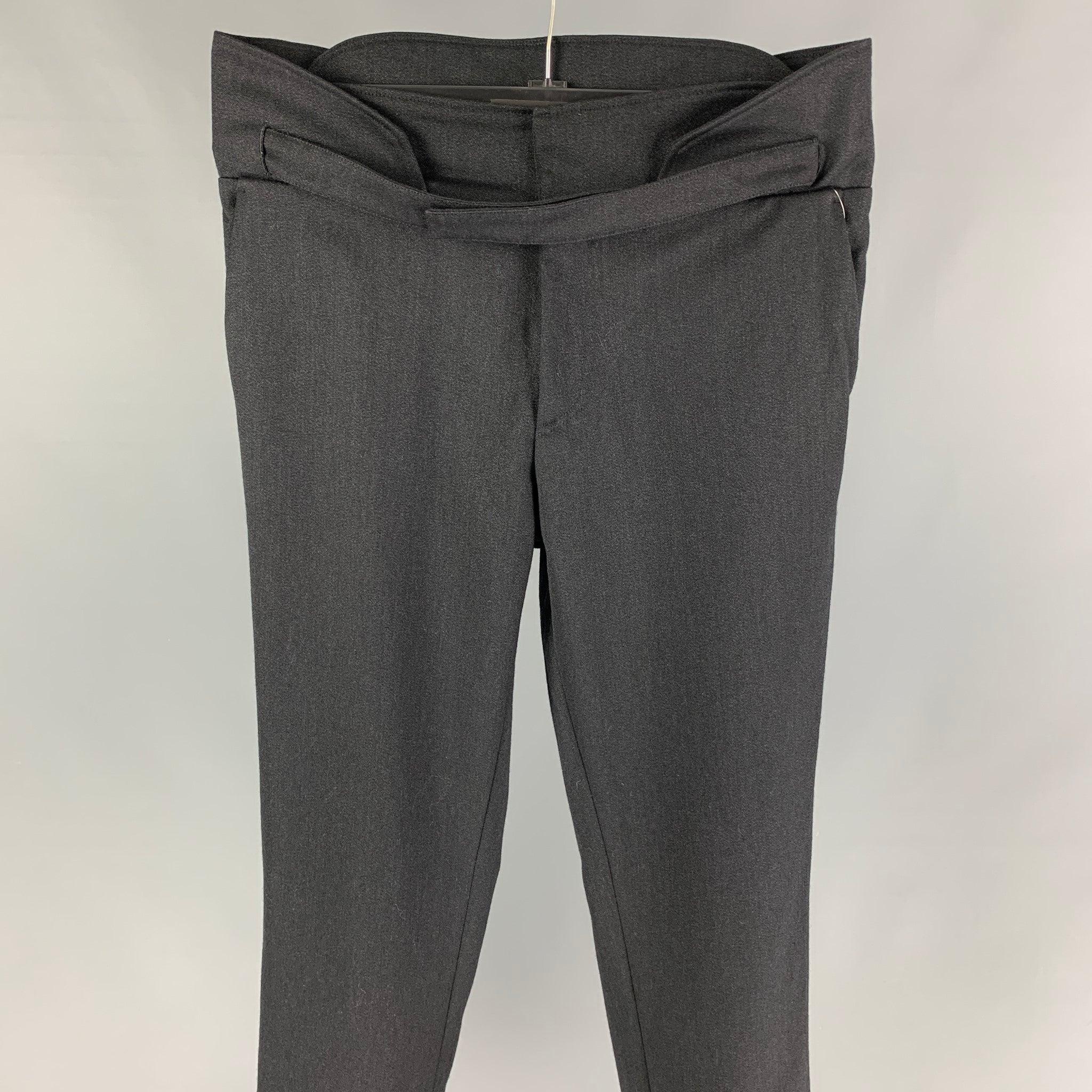 Vintage RAF SIMONS Fall 2016 dress pants comes in a black wool featuring a high waist, front strap tab closure, slim fit, back elastic panel, and a zip fly closure. Made in Romania. Very Good
 Pre-Owned Condition. 
 

 Marked:  50 
 

 Measurements:
