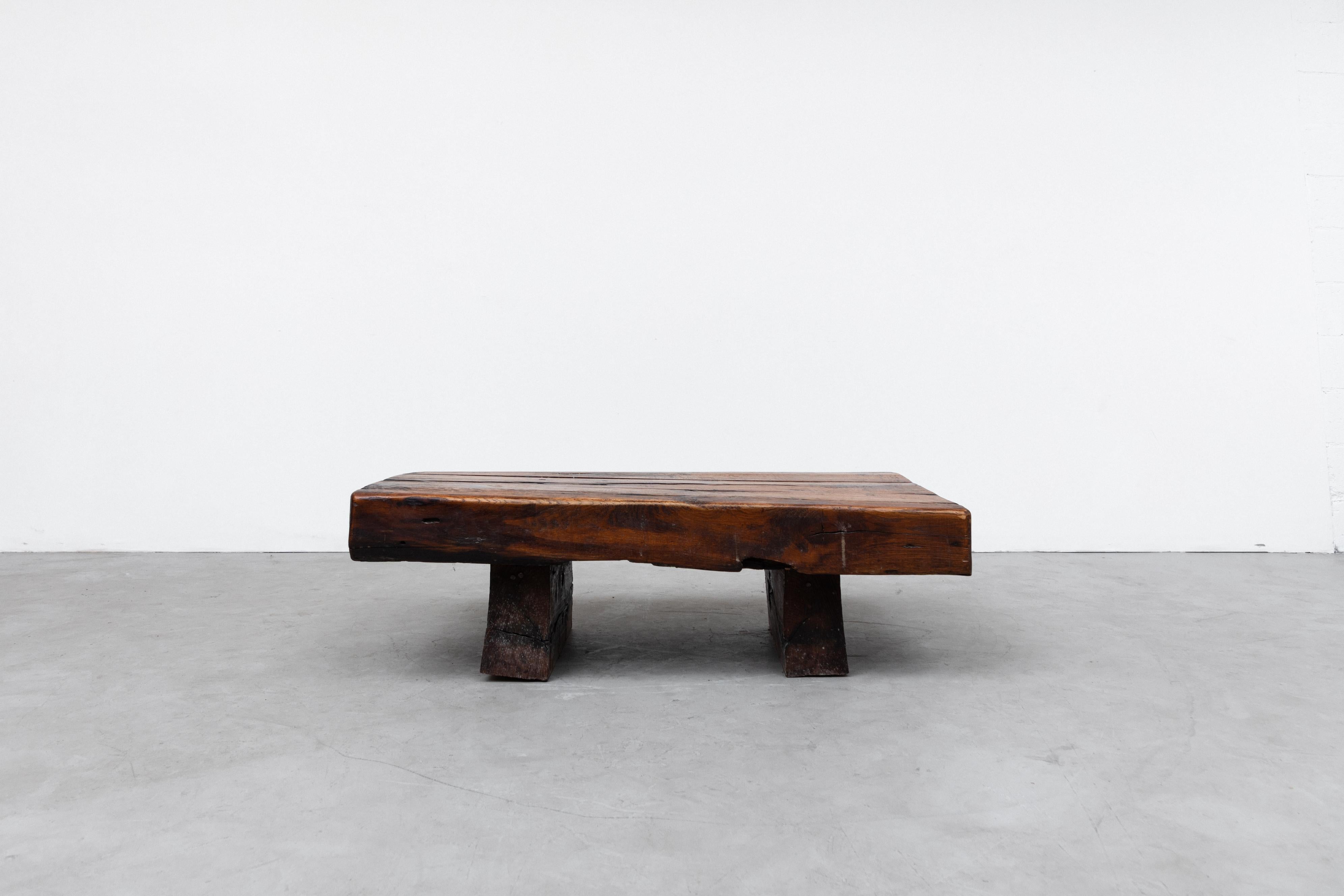 Heavy mid-century railroad tie coffee table in original condition with solid wood legs. Visible wear and scratching consistent with age and use. A similar round coffee table also available and listed separately (LU922424459652).