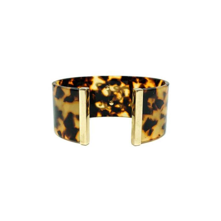A Vintage Ralph Lauren Cuff. Featuring a broad faux tortoiseshell plastic open cuff tipped with gold plated metal ends and adorned with a stylish script Ralph Lauren monogram in gold plated metal. Lovely quality, signed, in very good vintage