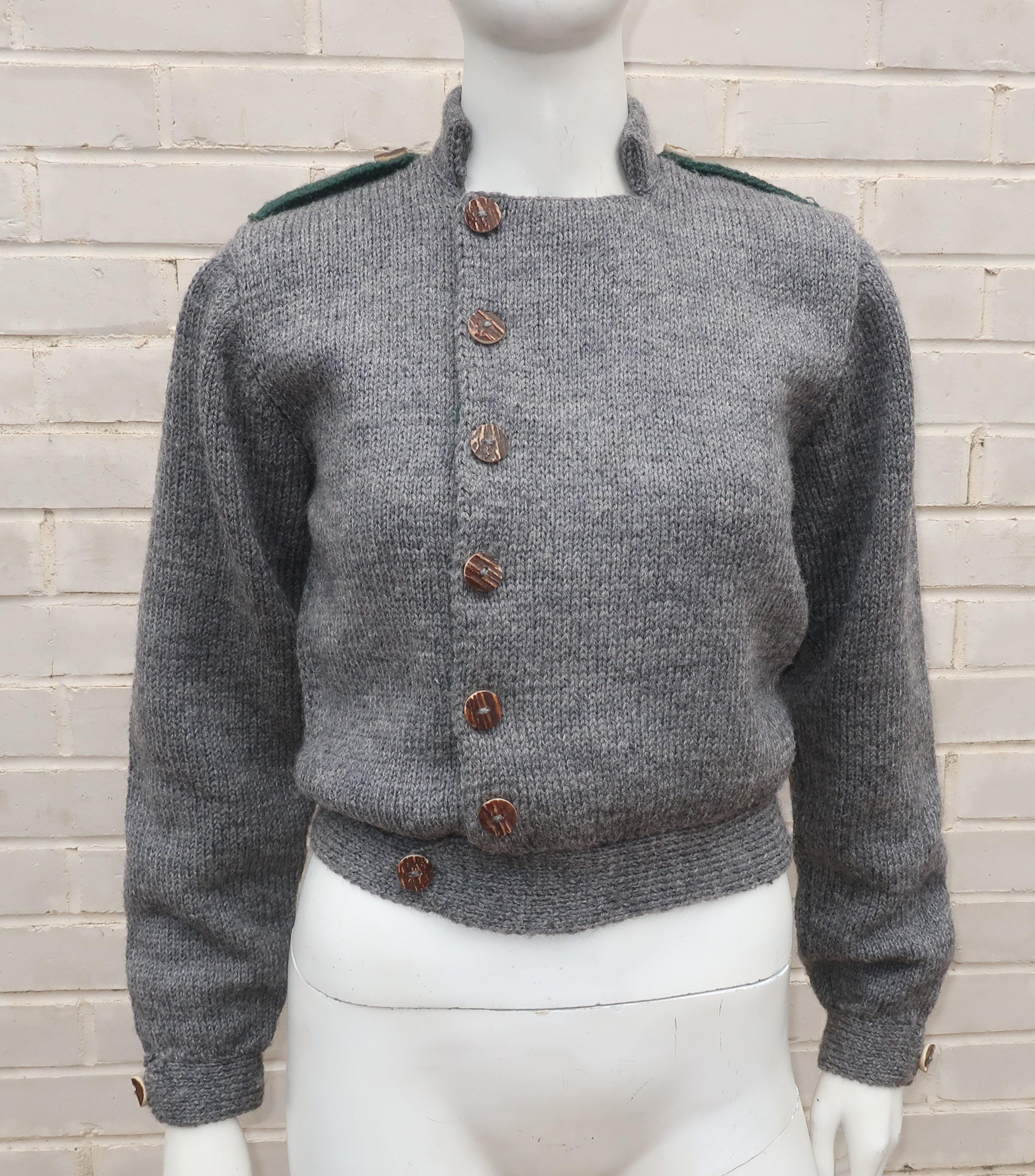 In this sweater jacket, Ralph Lauren creates great American style with a nod to a British past.  The hand knitted gray wool is accented with a dark green liner at the inside front and shoulder loops along with chunky horn buttons.  It buttons just a