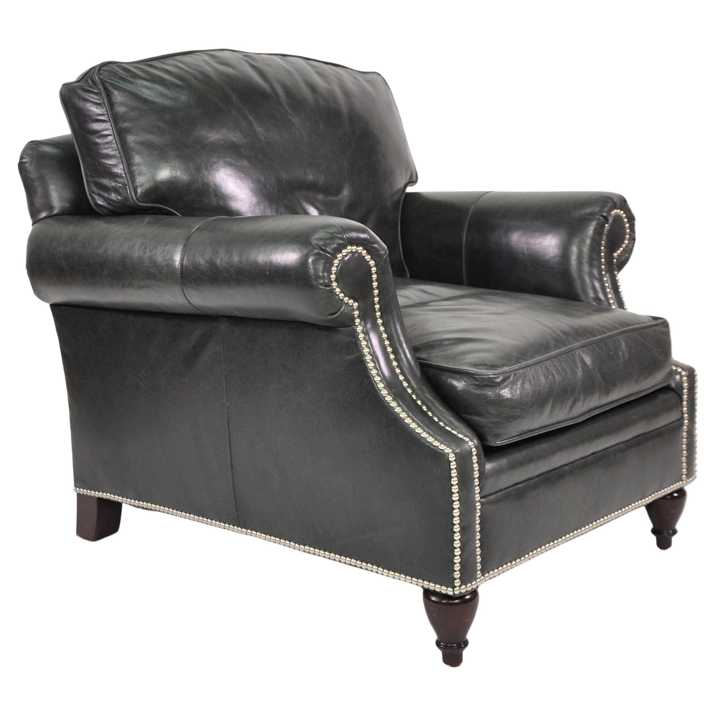 Luxurious Ralph Lauren leather lounge chair with nailhead trim and turned mahogany wood legs. The Regency style armchair has very comfortable, down-filled cushions and elegant English rolled arms. It's stylishly covered in a gorgeous Ralph Lauren