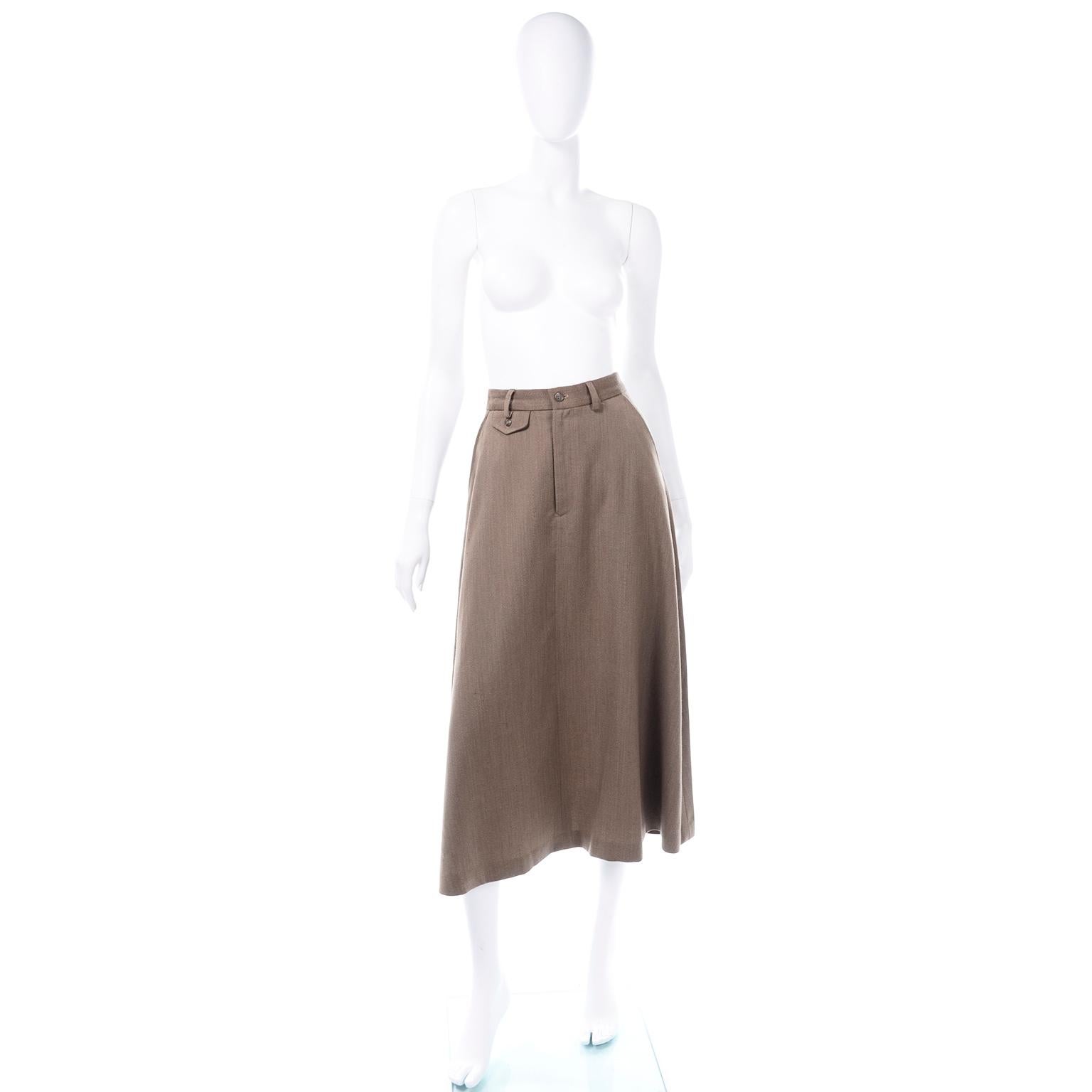 This is a classic late 1970's Ralph Lauren a-line midi skirt in a brown twill wool. It has modern  trouser styling, with a front button and zipper, belt loops, button flap slit back pocket, and small button flap pocket in front. It is unlined. This