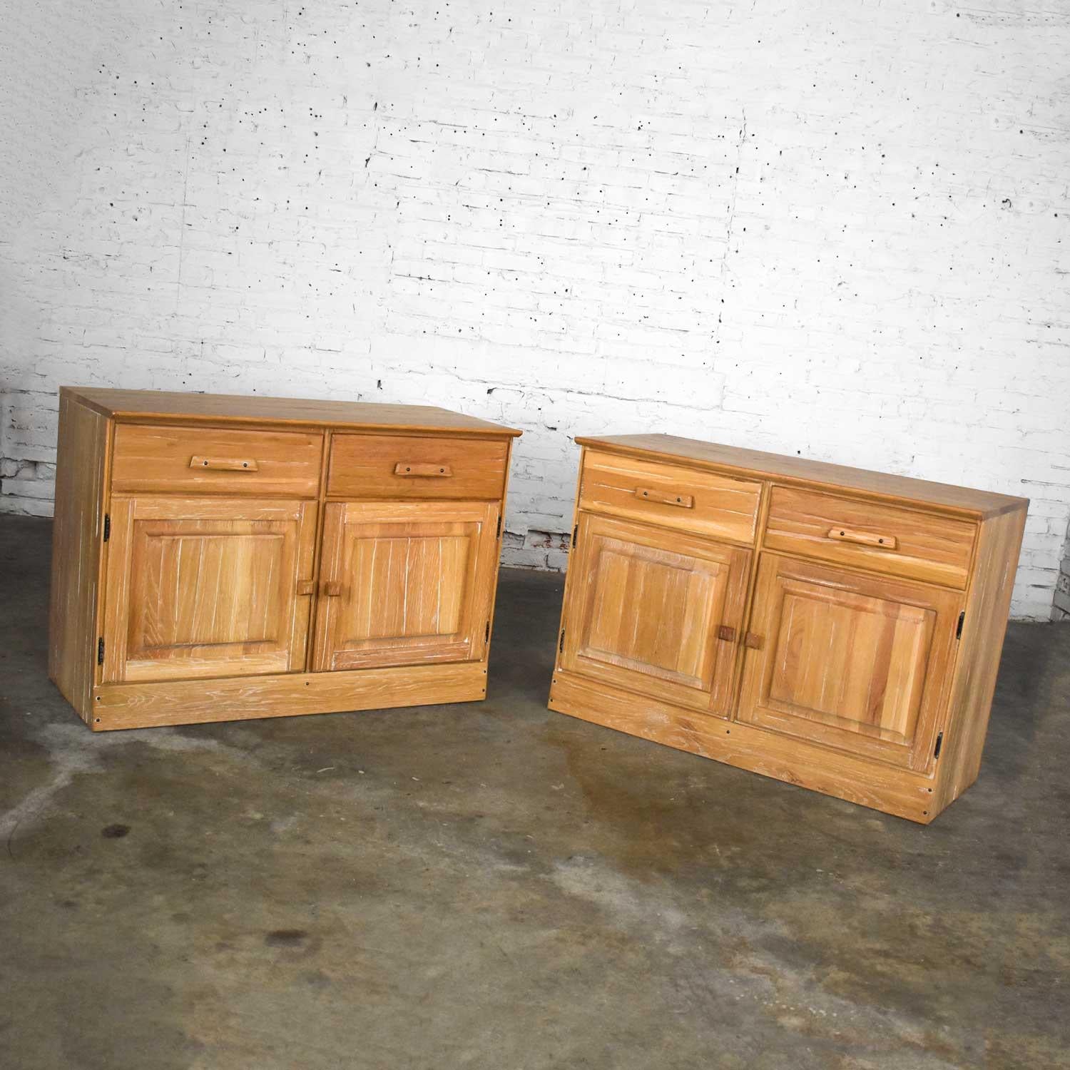 Fabulous pair of small credenzas or buffet cabinets by A. Brandt Company comprised of solid ranch oak with a natural oak finish. Wonderful vintage condition. One top has a joint crack that had occurred from age, but it has been repaired, it just