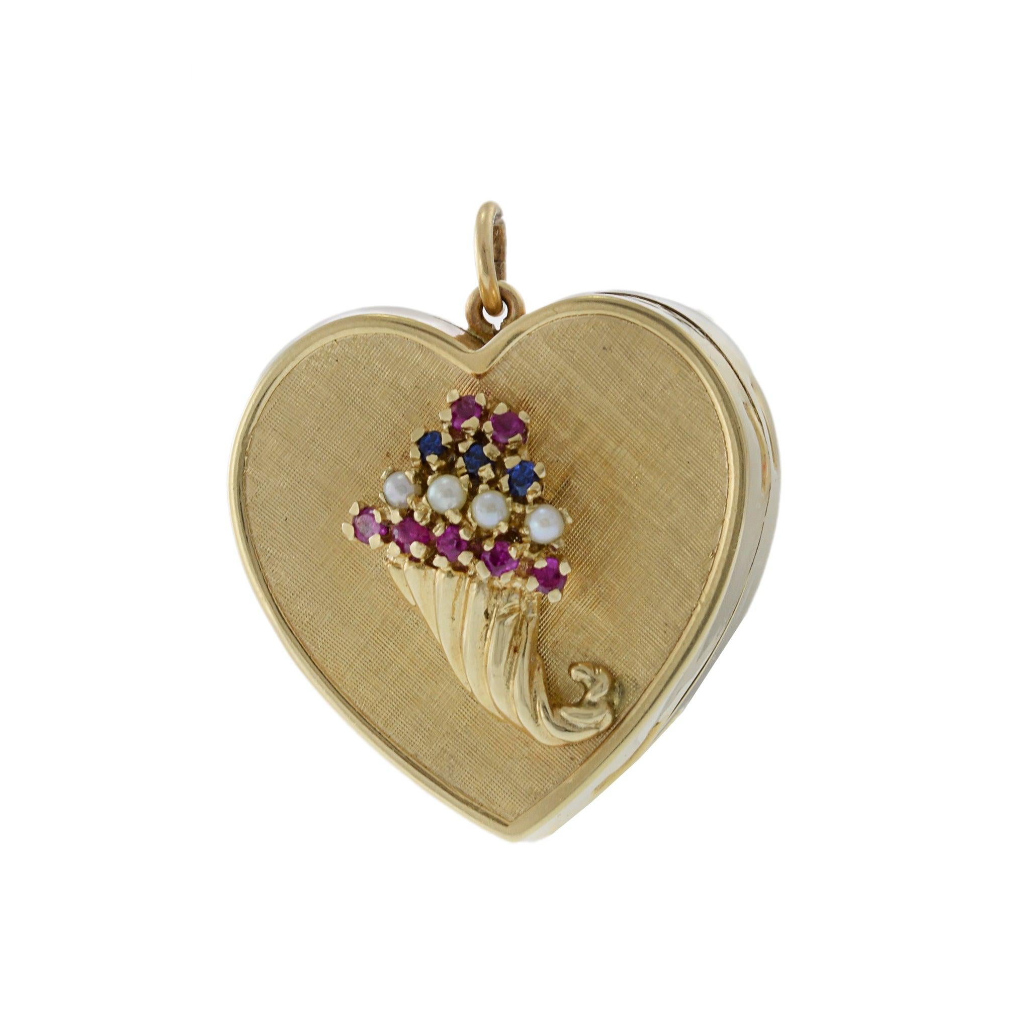 Vintage Rare 14KT Yellow Gold Hand-Wind Music Heart Box Pendant. This exquisite piece is adorned with round cut rubies, blue sapphires, and seed pearls. Crafted from luxurious 14KT yellow gold, this charming heart-shaped music box plays a beautiful