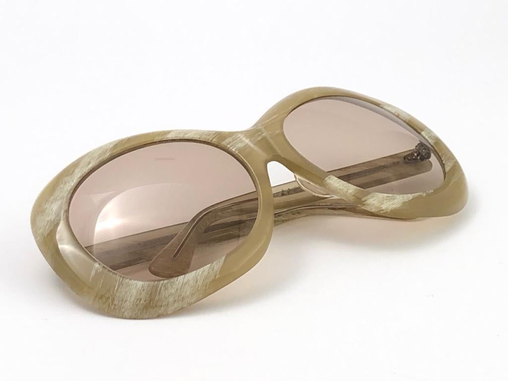 Vintage super rare oversized round beige with light brown lenses sunglasses. 

Amazing craftsmanship and style.

Measurements :
Front : 15.5 cms

Lens Height : 5.4 cms

Lens Width : 6.2 cms

