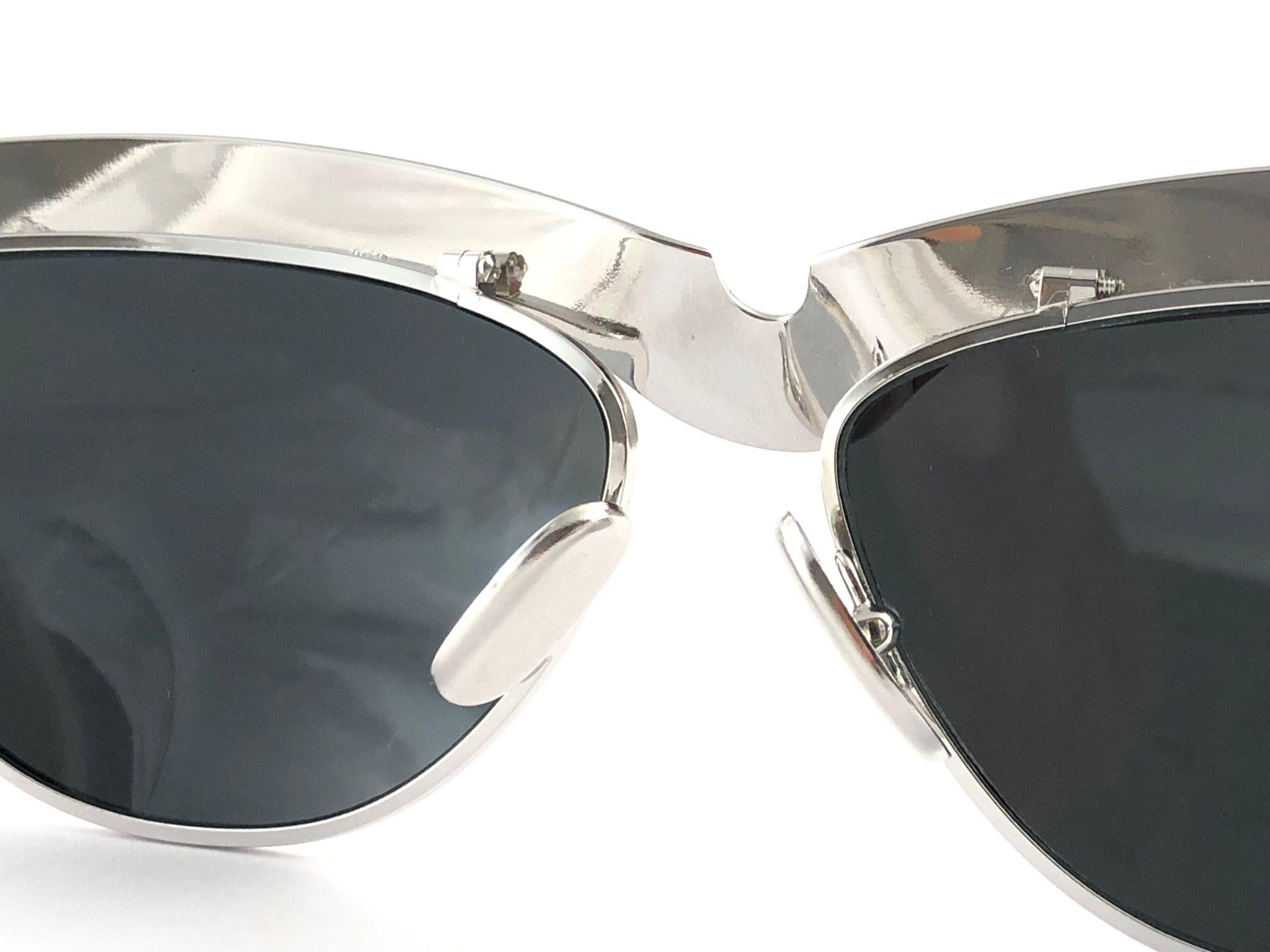 Seldom Vintage Rare Alain Mikli silver frame.

Full  mirror lenses.

Please consider that this item is nearly 40 years old so it could show minor sign of wear due to storage.

Made in France.


MEASUREMENTS :

FRONT : 15 CMS
LENS HEIGHT : 4 CMS
LENS