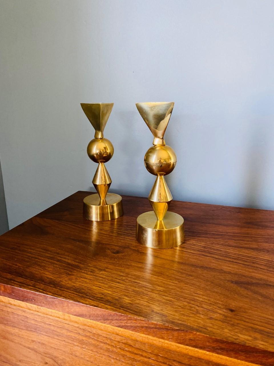 Stylish and incredibly modernist set of goldplated over brass candle holders in the style of Tommi Parzinger for Mueck-Cary. Elegant, with an undeniable silhouette that brings joyful midcentury design. Very unique and will add a special touch to