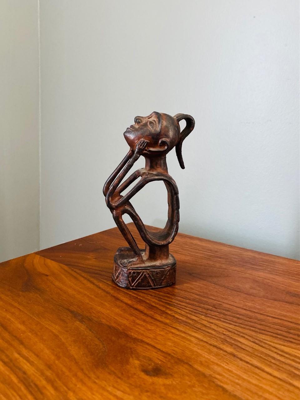 Bellissima e rara figura vintage.  Stilisticamente primitiva e grezza, questa bellissima statua in bronzo rappresenta un vecchio antenato o un'anima protettiva.  La figura scheletrica e la grande testa evocano un chiaro collegamento che allude alla