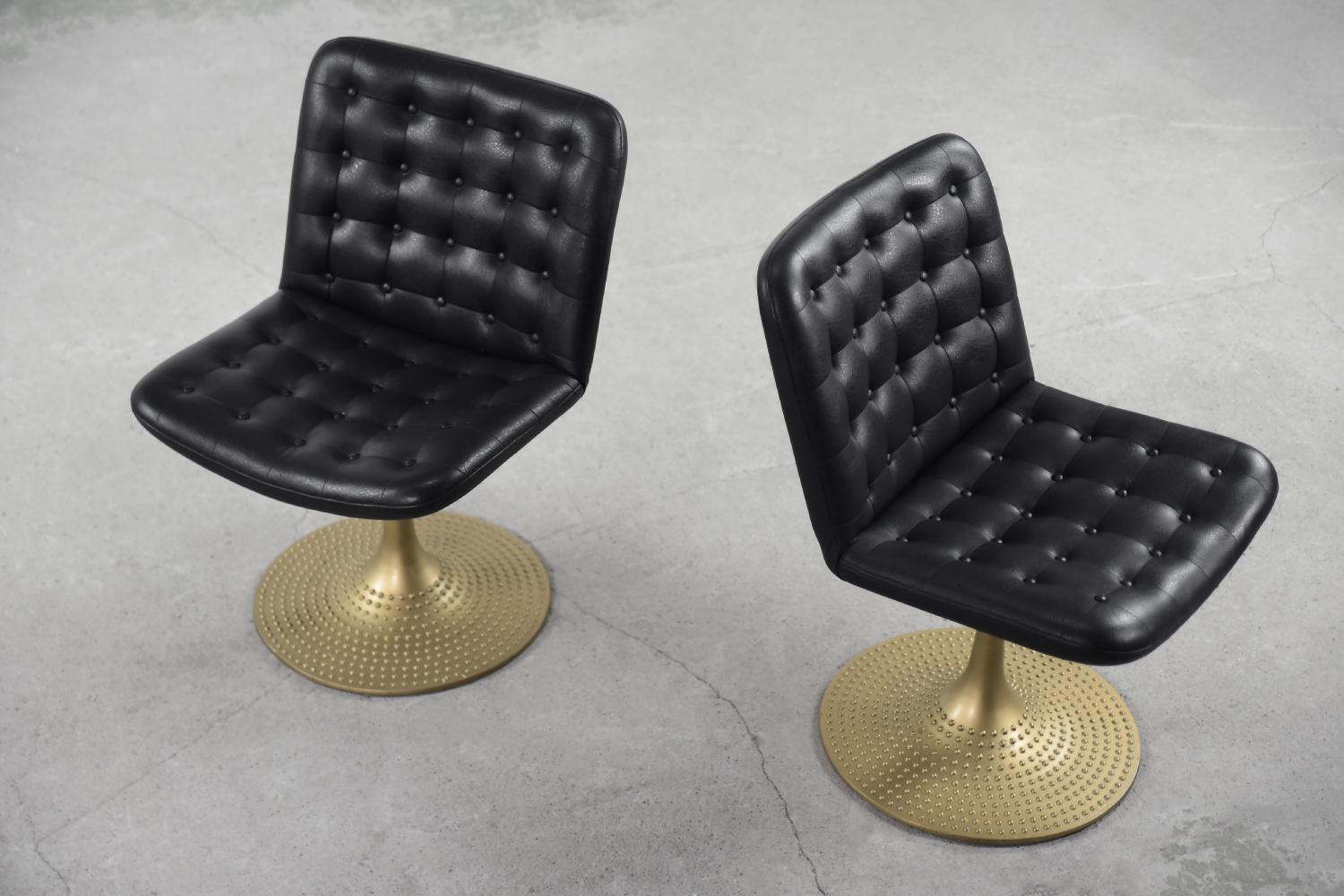 This set of two rare chairs was designed by Yrjö Kukkapuro for the Finnish Lepo Finn manufactory during the 1960s. The chairs are upholstered in black synthetic leather with quilting. The base is a decorated and finished in golden color, rotating