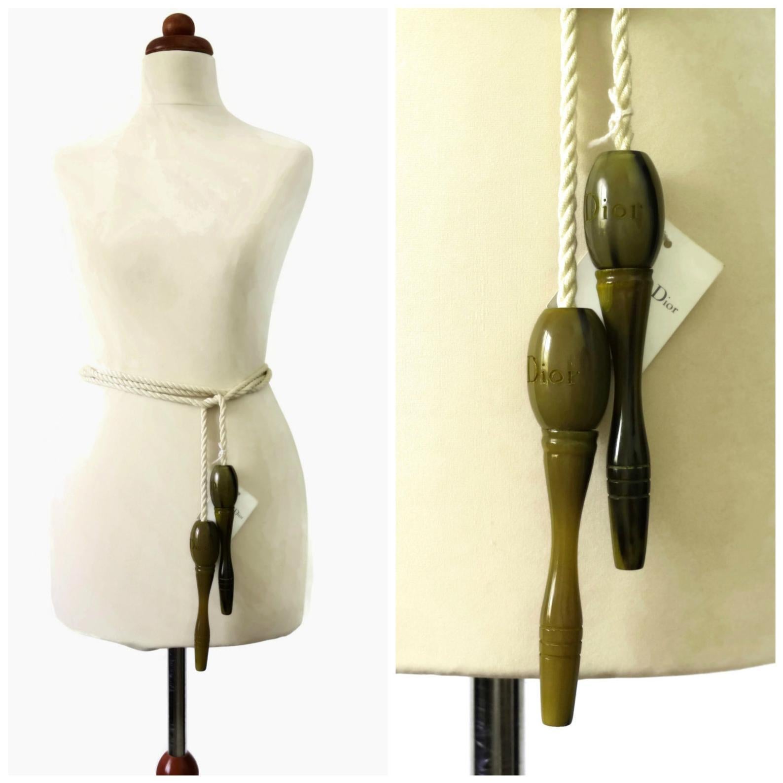 Vintage Rare CHRISTIAN DIOR Resin Jumping Rope Belt

Measurements:
Handle Height: 6 2/8 inches
Handle Width: 1 2/8 inches
Length: 102 2/8 inches

Features:
- 100% Authentic CHRISTIAN DIOR.
- Marbled olive green handles with engraved DIOR on each.
-
