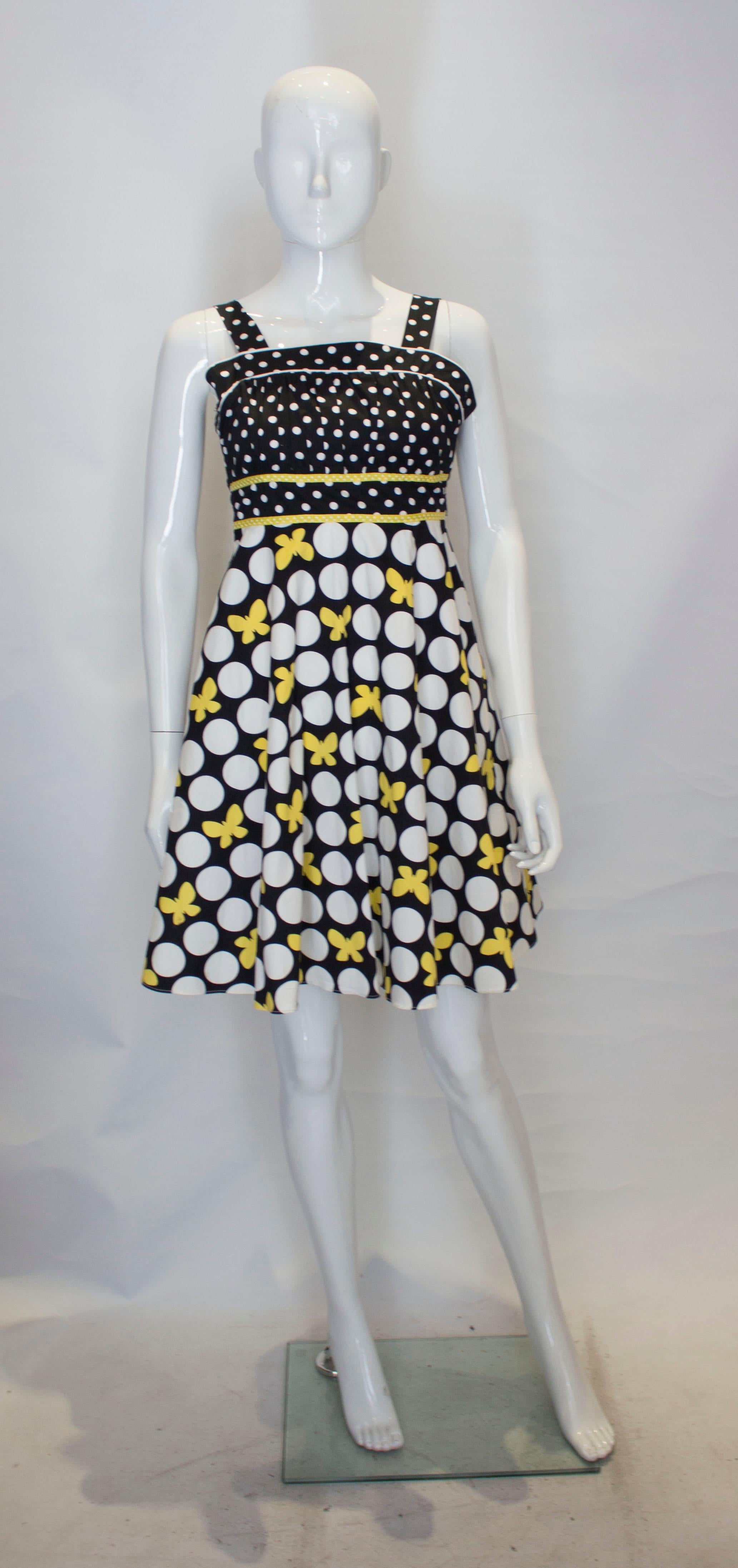 A pretty and fun cotton sundress by Rare Editions. The cotton dress has wide shoulder straps, vertical gathering on the bust area and a flared skirt. It has a central back zip , that does work, the dress is too small for the mannequin. It is lined
