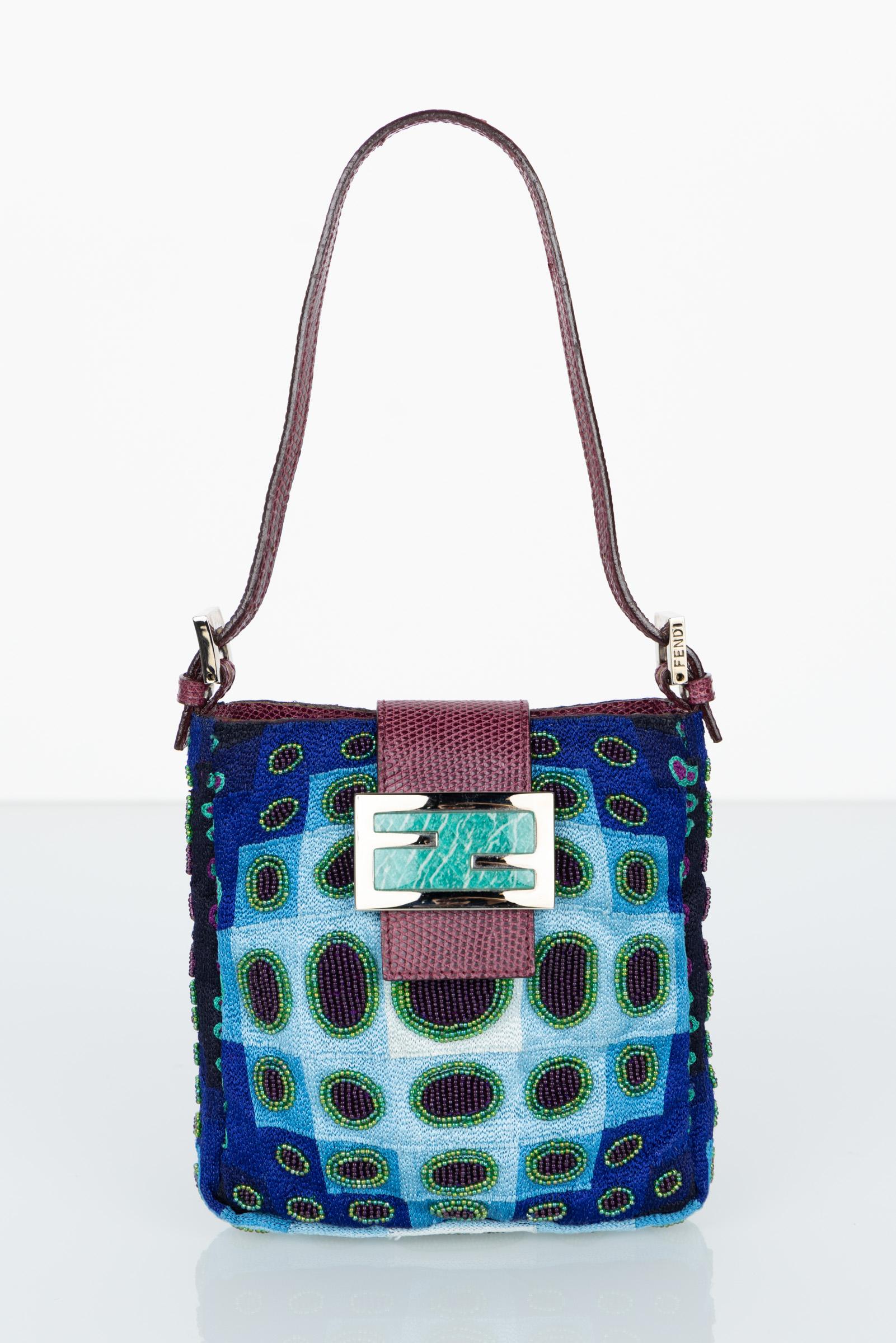 A unique and exquisite vintage Fendi mini bag with a distinctive design and luxurious features. The combination of blue-green turquoise embroidered silk tapestry with hand-beaded circles and ovals, along with burgundy lizard trim handles, creates a