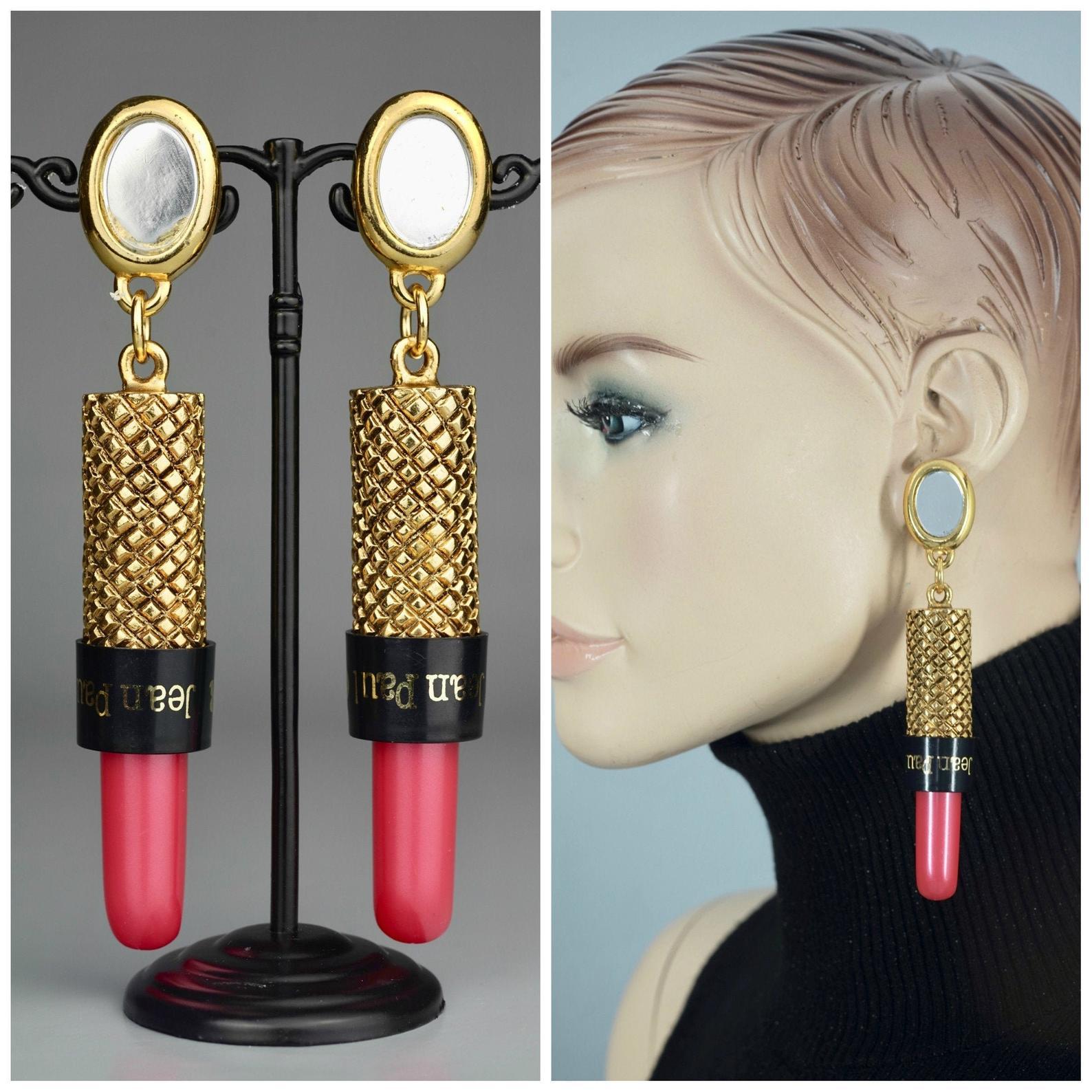 Vintage Rare JEAN PAUL GAULTIER Lipstick Drop Earrings

Measurements:
Height: 4.65 inches (11.8 cm)
Width: 0.79 inch (2 cm)
Weight: 23 grams

Features:
- 100% Authentic JEAN PAUL GAULTIER.
- Massive novelty mirror and lipstick drop earrings.
- Gold